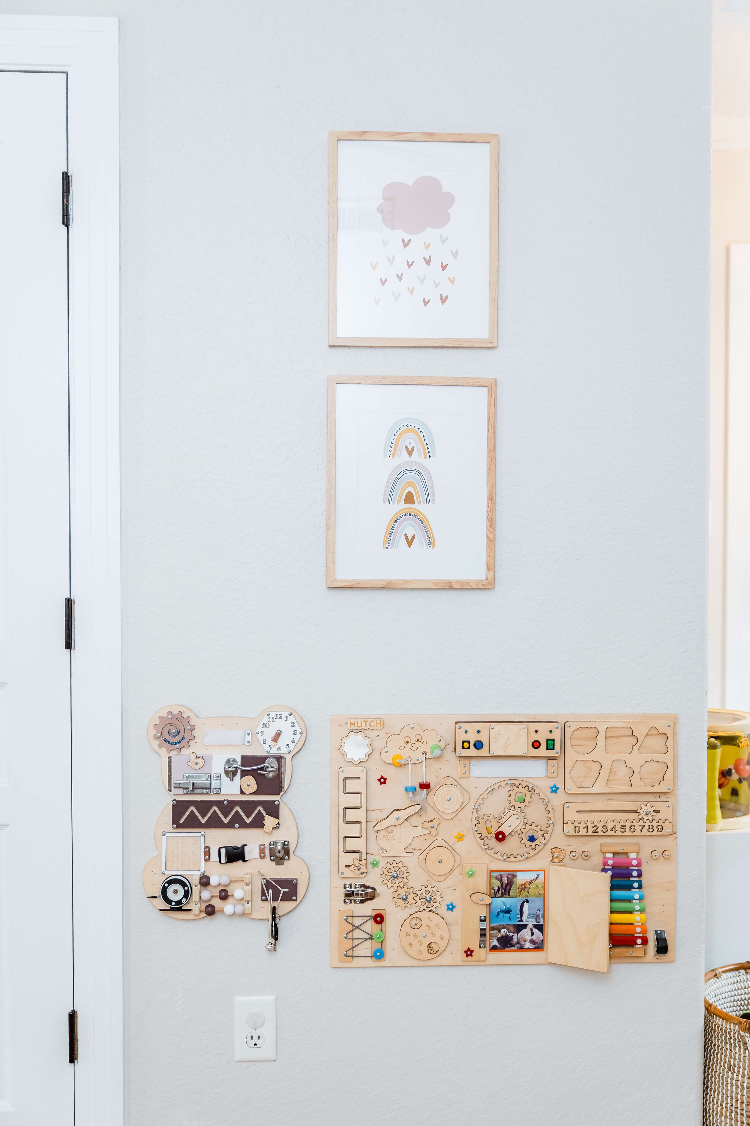 Girls artwork and wall mounted educational toys in playroom.