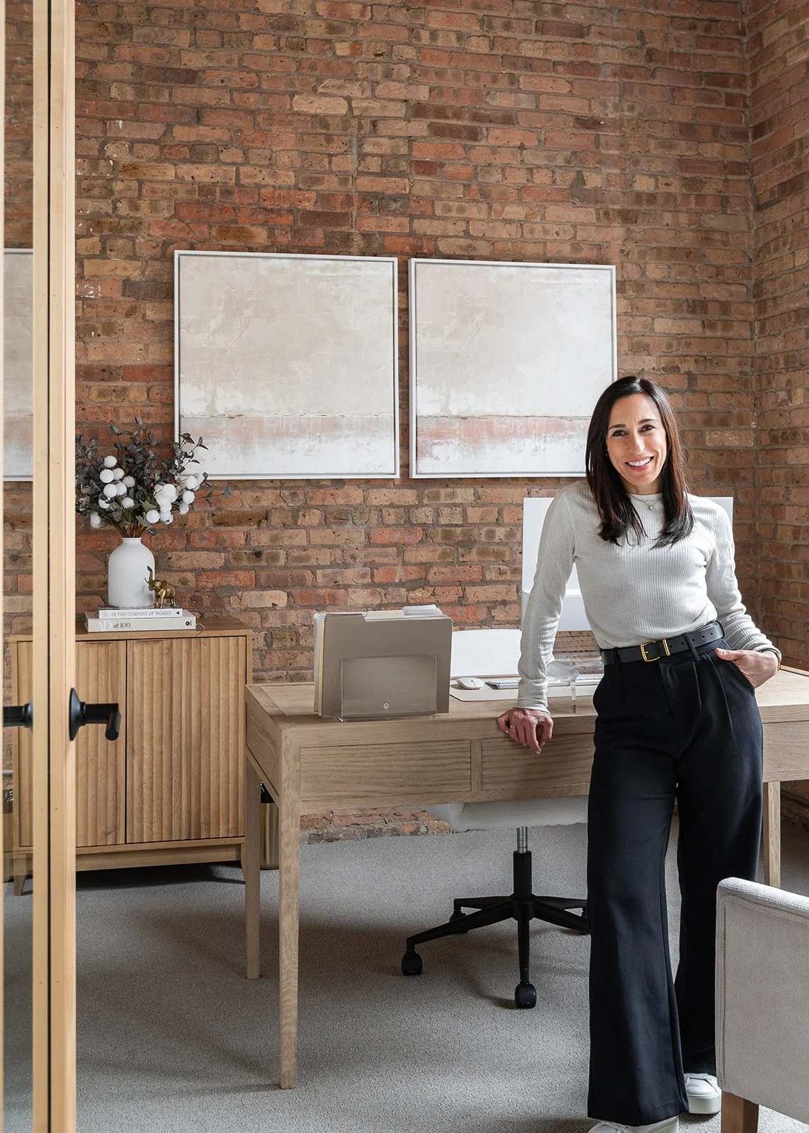 Interior designer styling an executive office meeting area in a Chicago loft for a retail leadership team