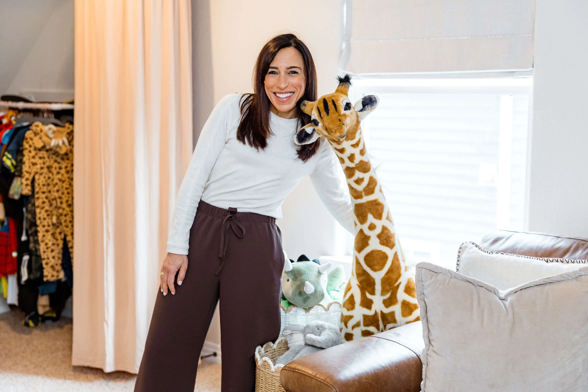 Carly from CarMELLA hanging out with giraffe in playroom. 