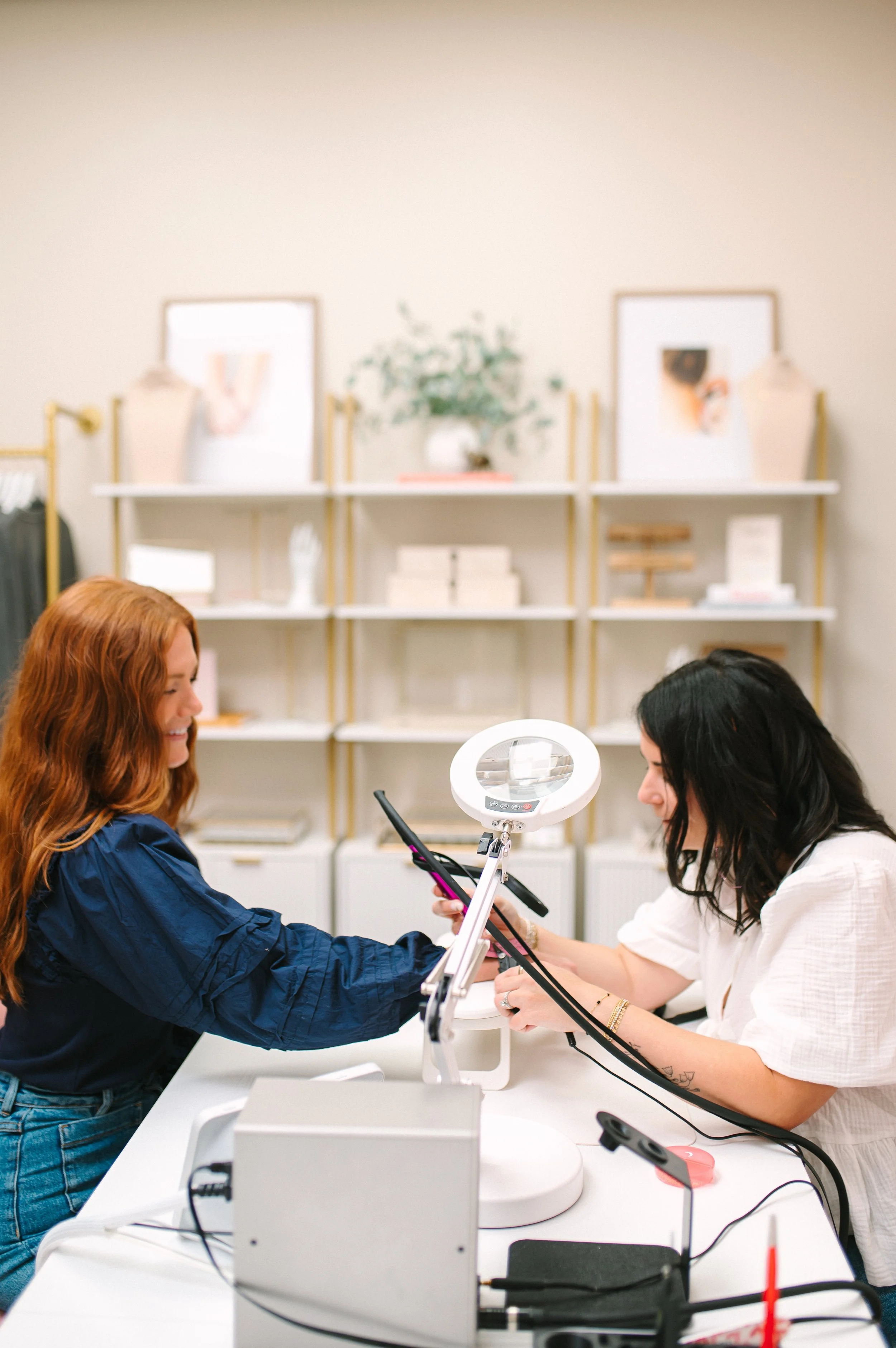 Danity and Dazzled customer getting permanent bracelet by owner in retail space.