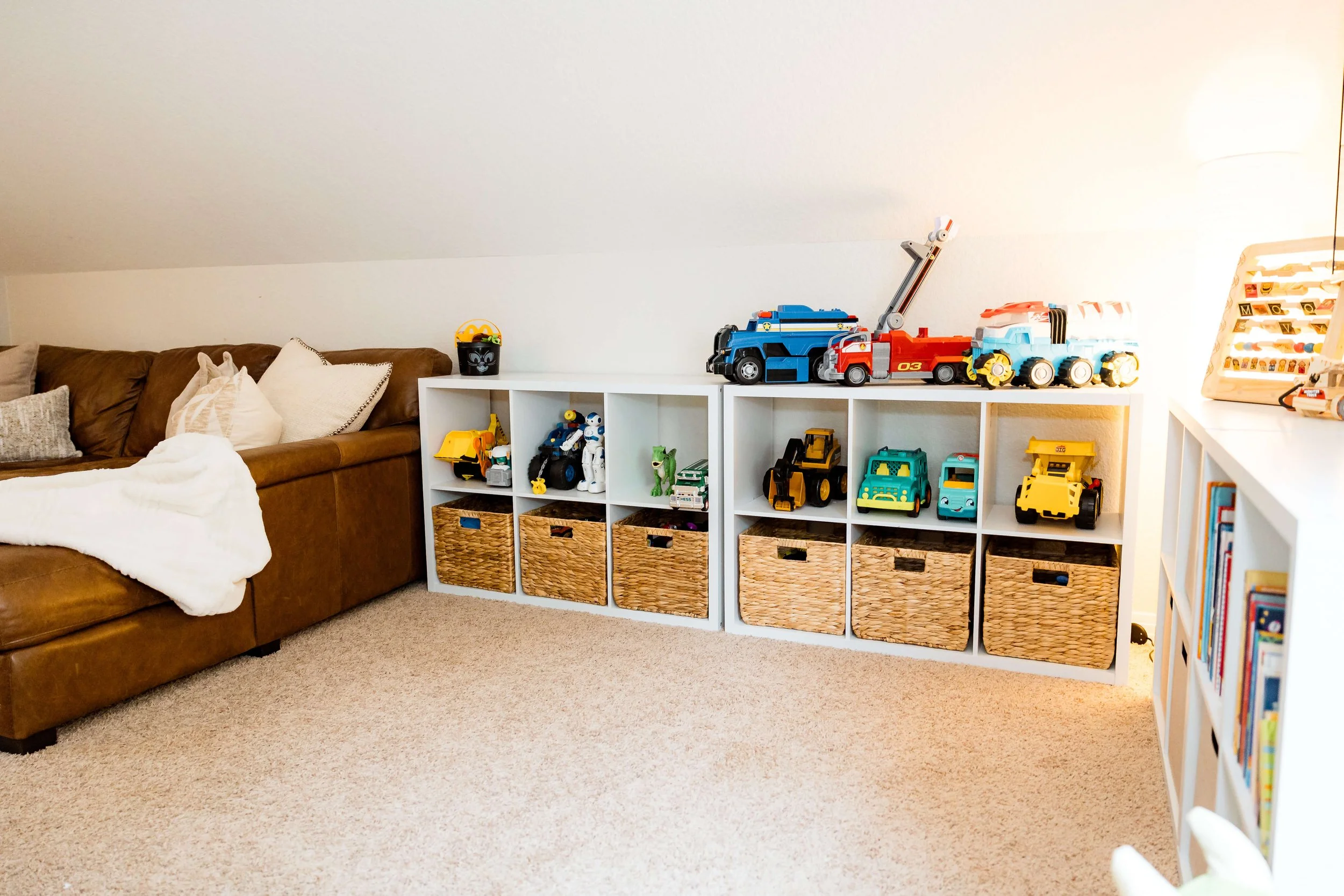 Organized playroom with cube storage units holding little boys toys.