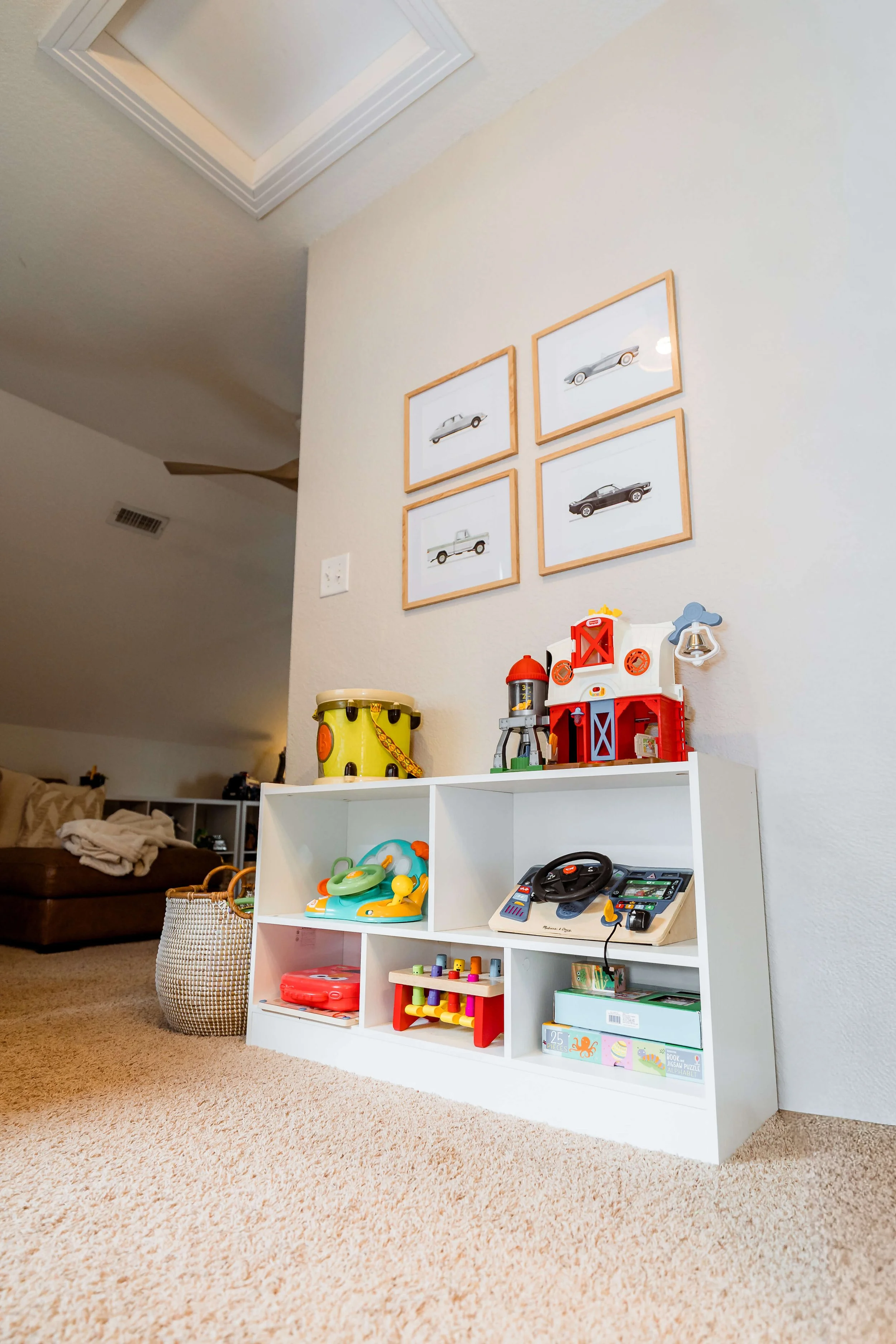 Little boy car artwork and storage unit for toys in playroom.