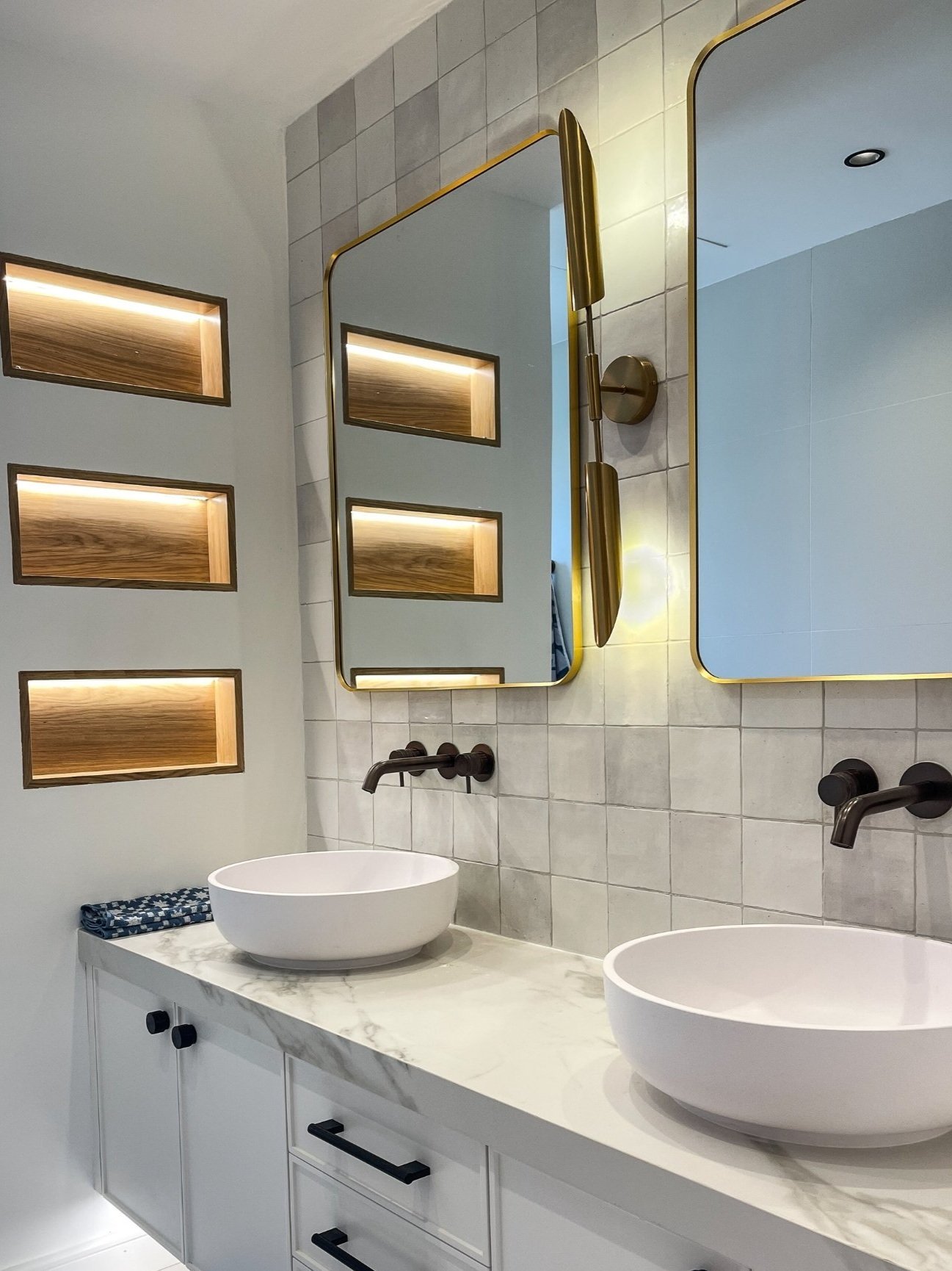 Modern powder room with marble countertops, gold fixtures, and ambient lighting."  Guideline: Clearly describe the main features of the bathroom to assist visually impaired users.