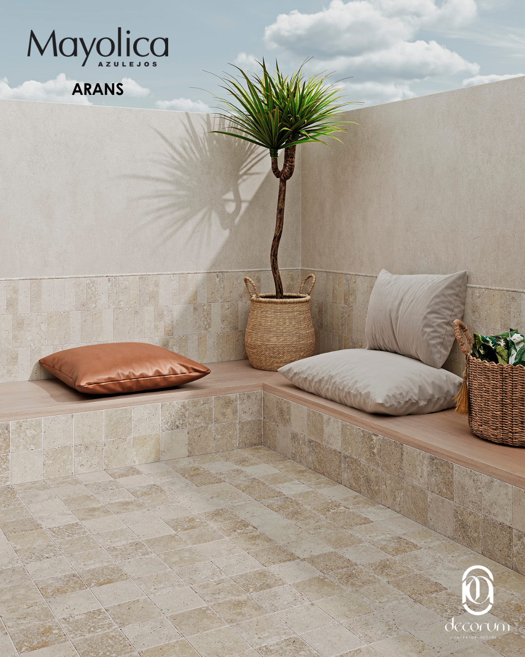 A corner with beige tiled walls and floor, with a wicker basket containing a tall green plant, a copper pillow on a wooden bench, and two light-colored pillows and a wicker basket with green plants.