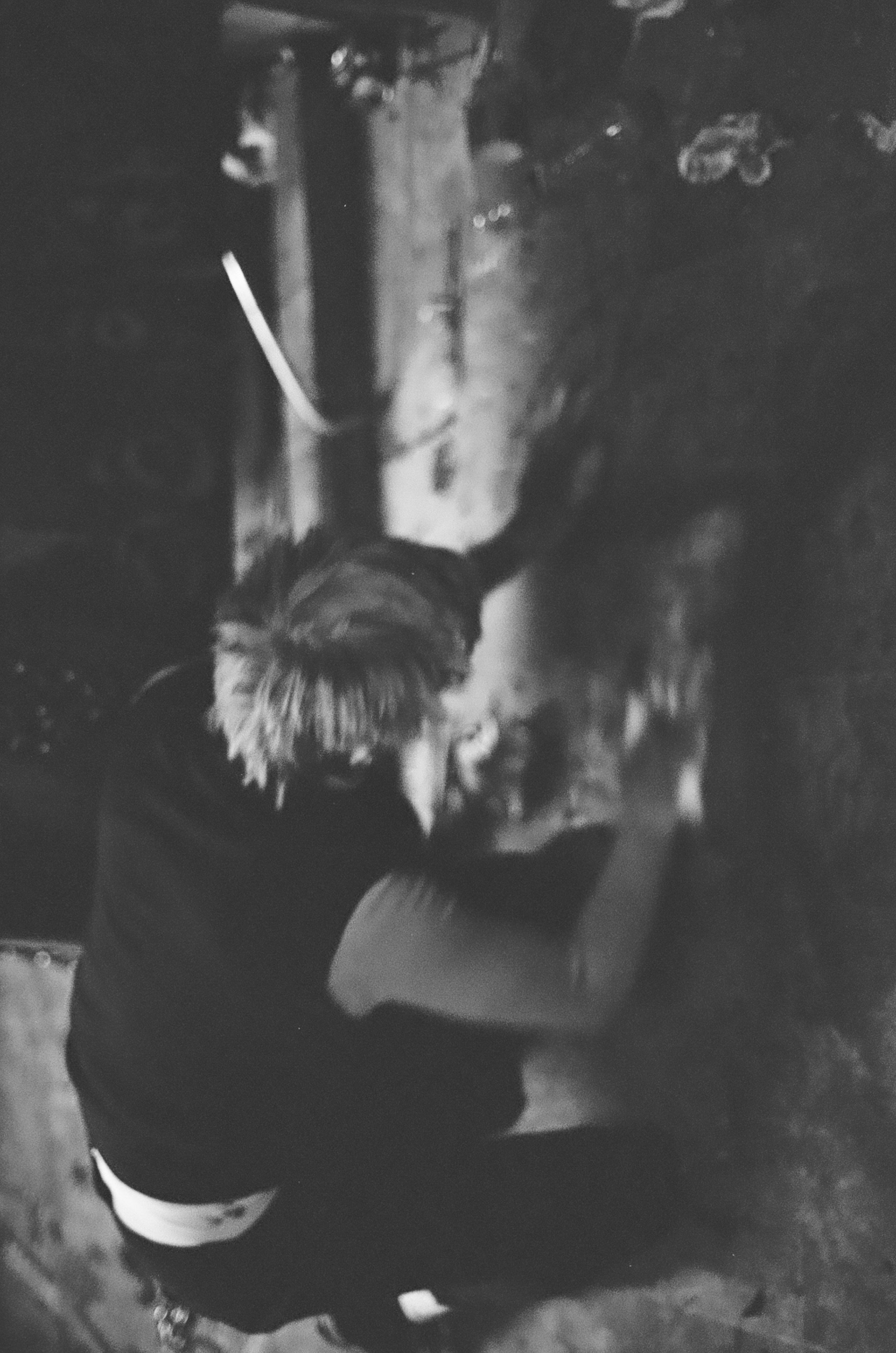 A person, with short hair, is hugging a dog that appears to be laying on the ground.