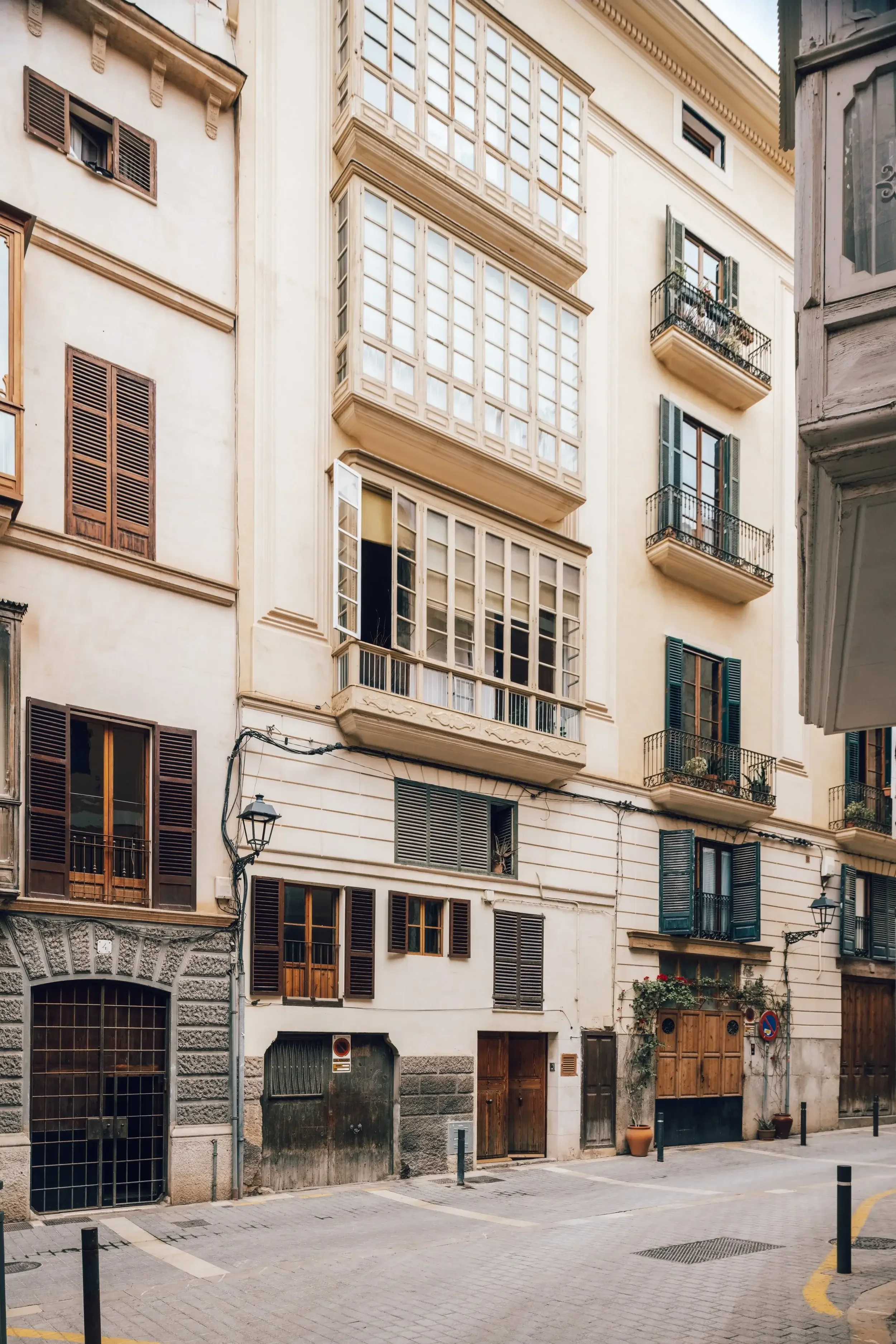 Shot of old European-style buildings with multiple windows and balconies on a quiet street.