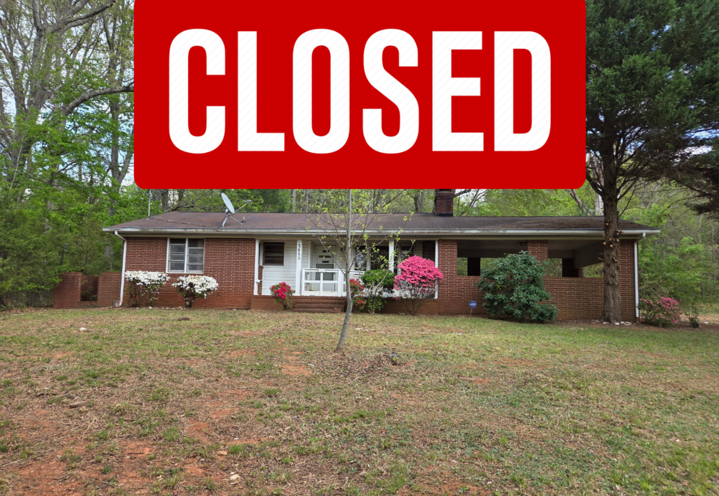 A single-story brick house with a small front porch, green and pink flowering shrubs, a young tree, and a lawn, with an "Under Contract" overlay