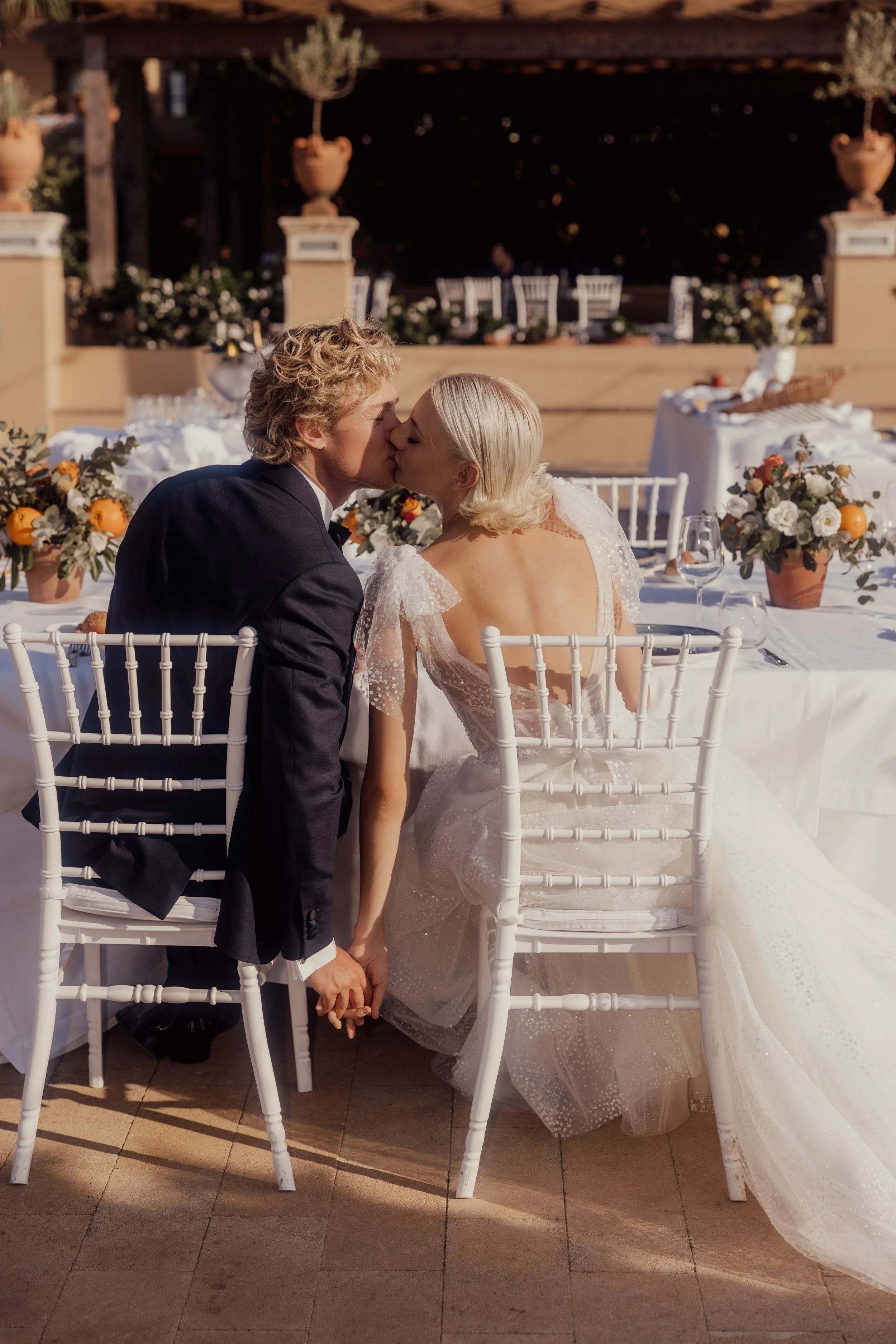Bride and groom kissing at wedding reception table