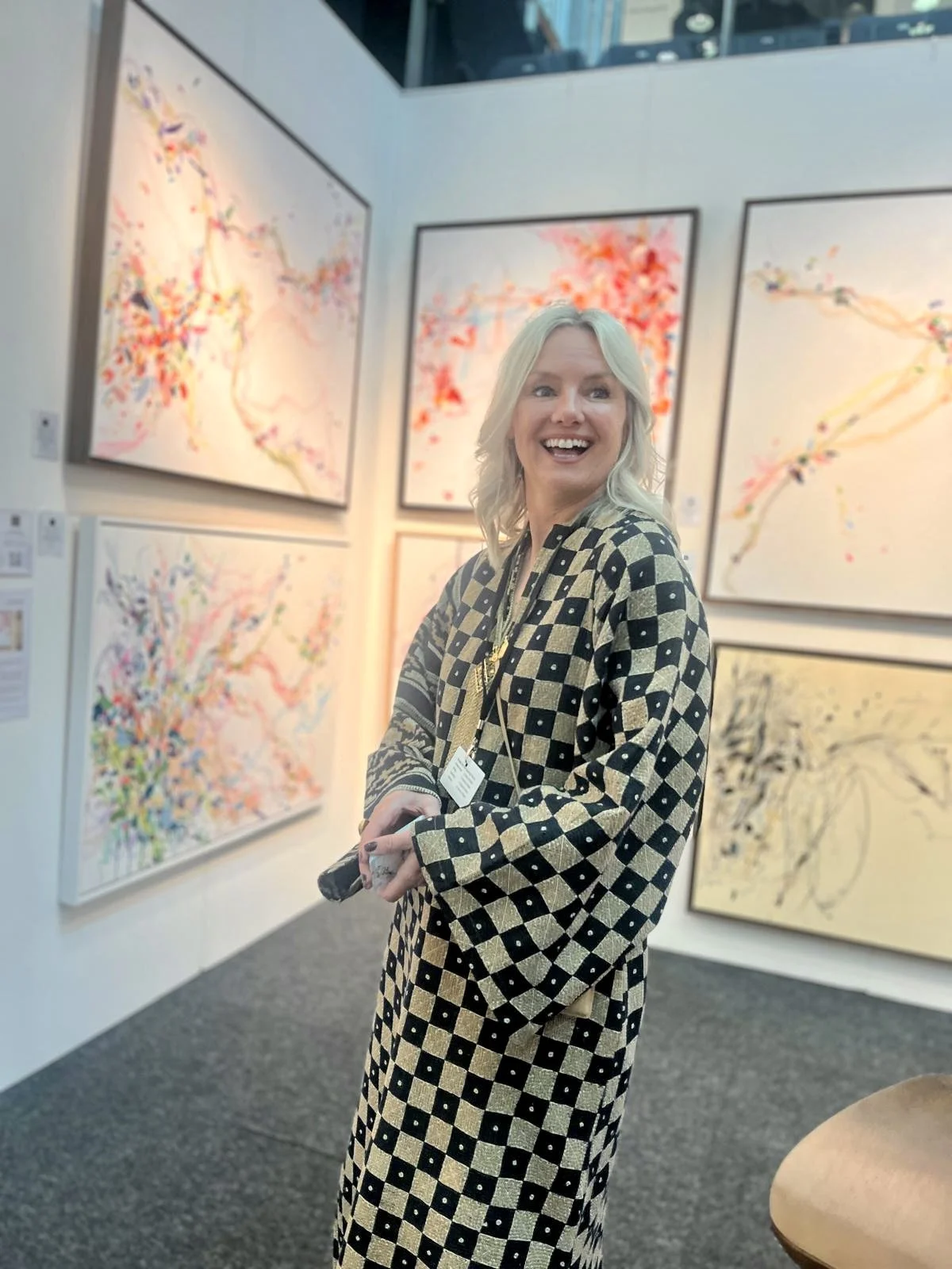 Artist Jo FitzGerald in front of her paintings at art show