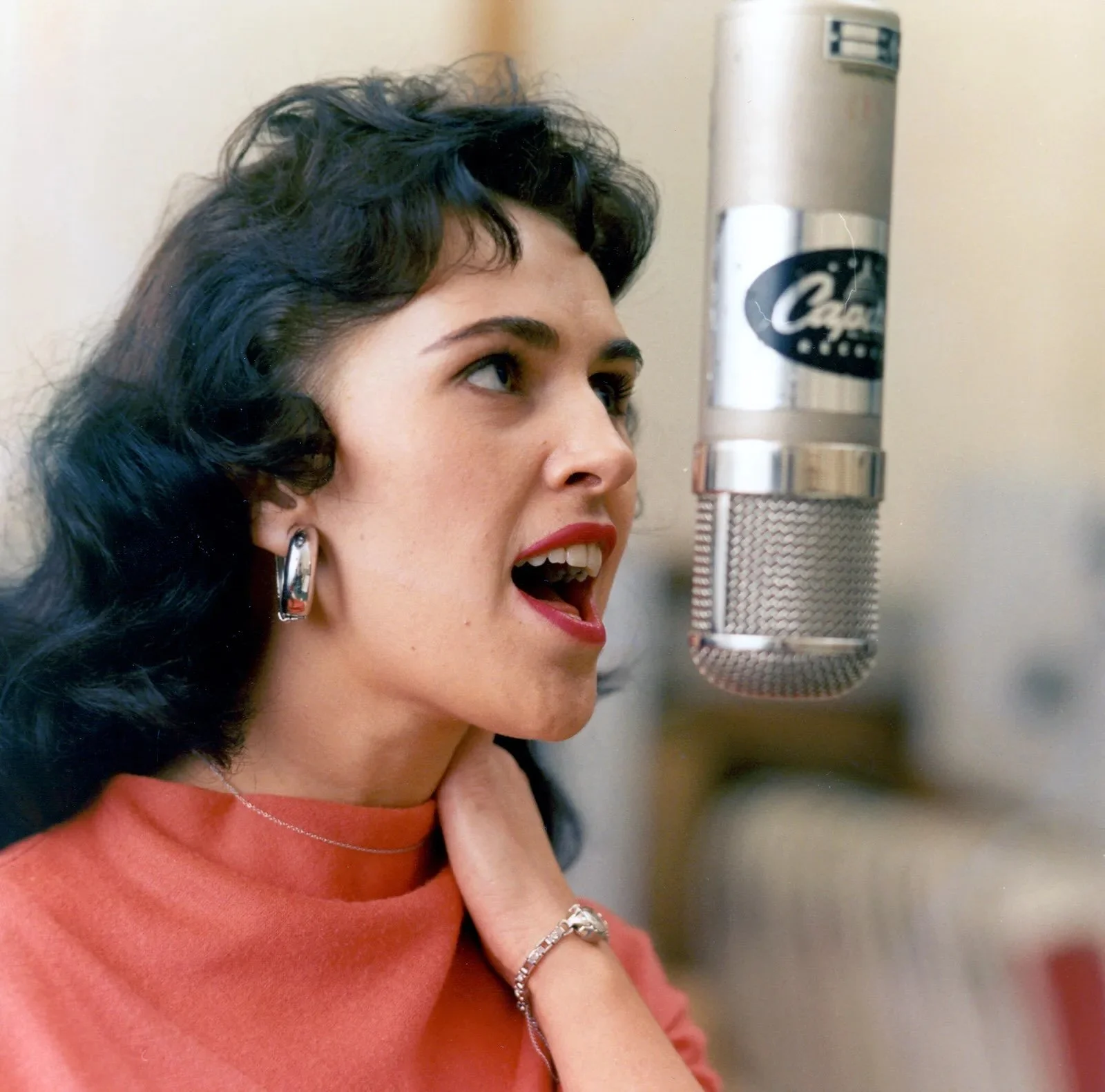 wanda jackson circa 1970 singing into a microphone