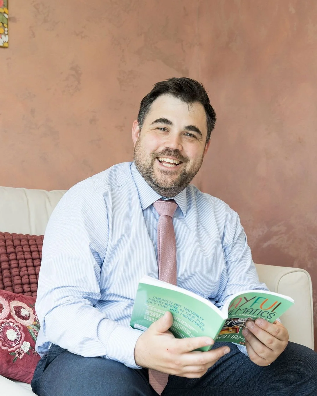 Scott, co-director and mathematics expert, reading a book on maths support and devlopment for children and young people