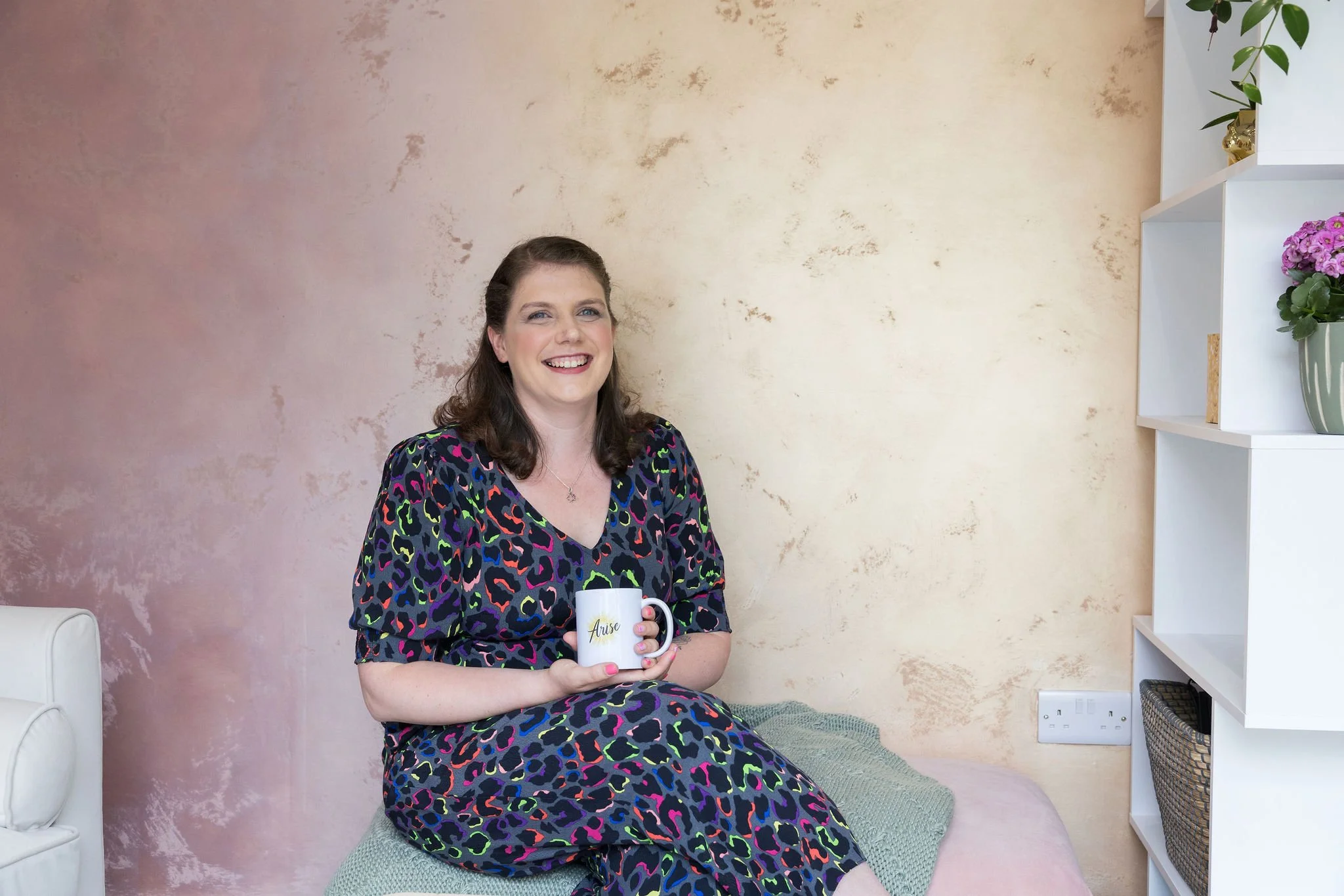 Deborah, lead educational psychologist and founder, holding a cup of coffee