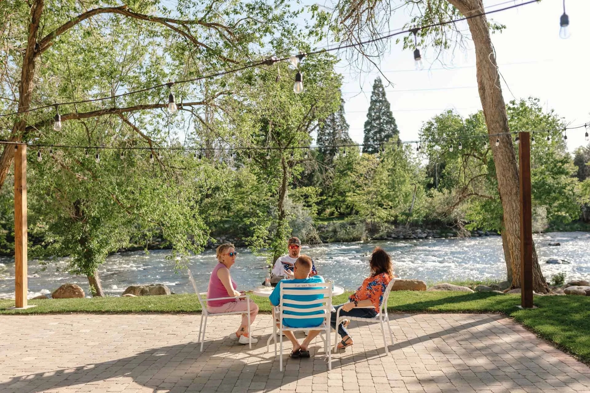 four people sitting at an outdoor table near the river.jpg