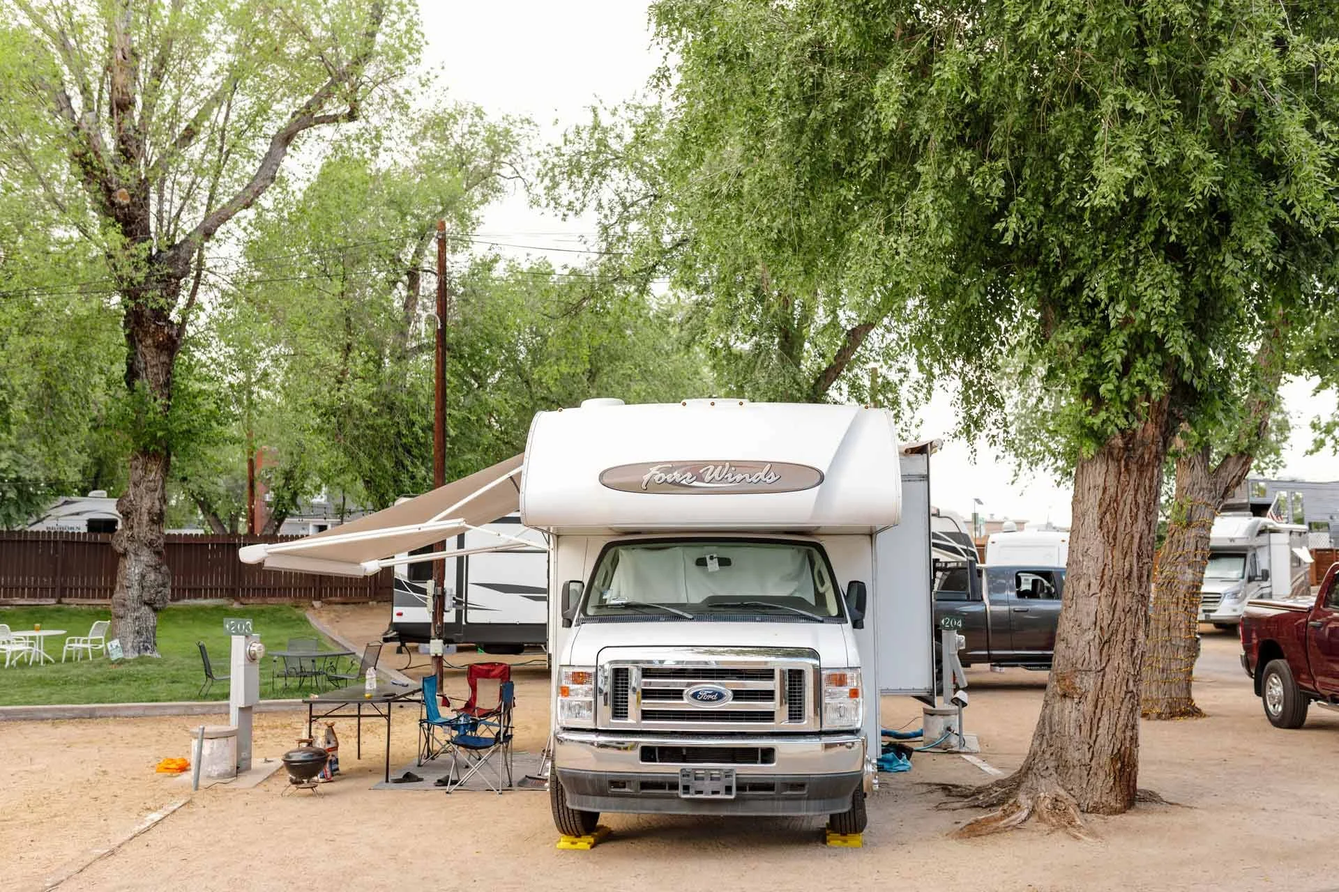 an-RV-parked-under-a-green-tree.jpg