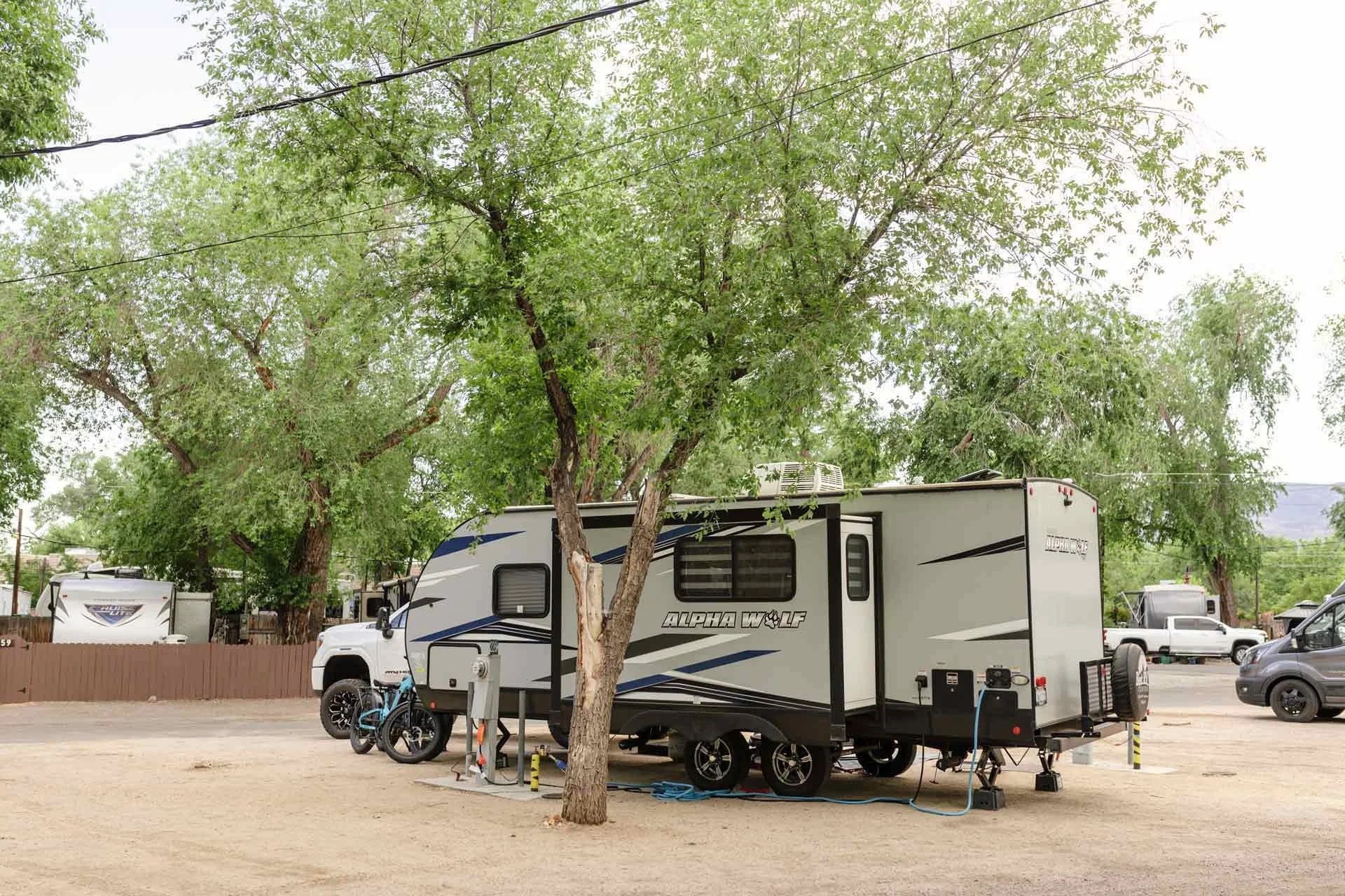 an-RV-parked-under-green-trees.jpg