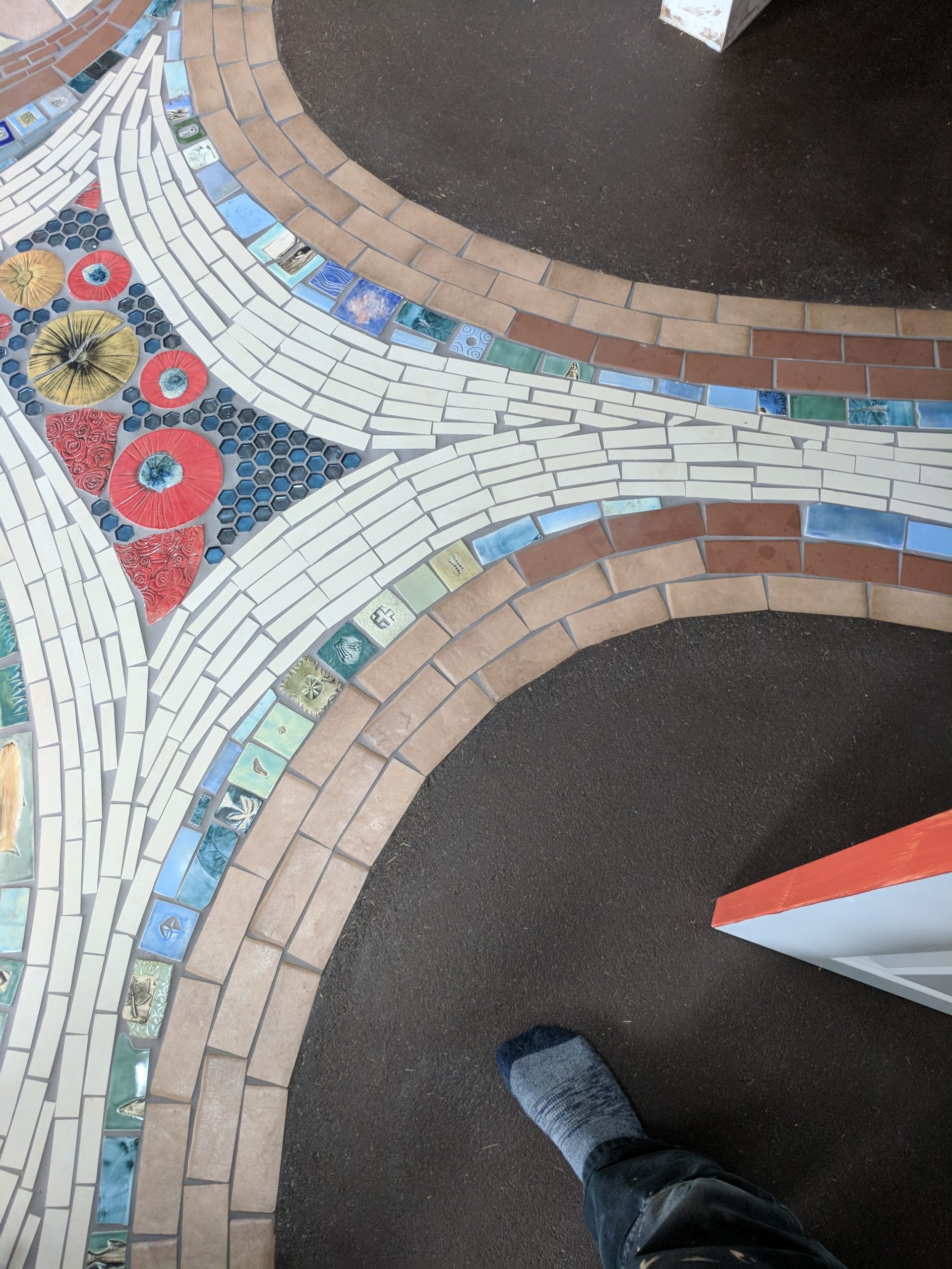 Craftsmanship detail of mosaic tile and earthen floor integration.