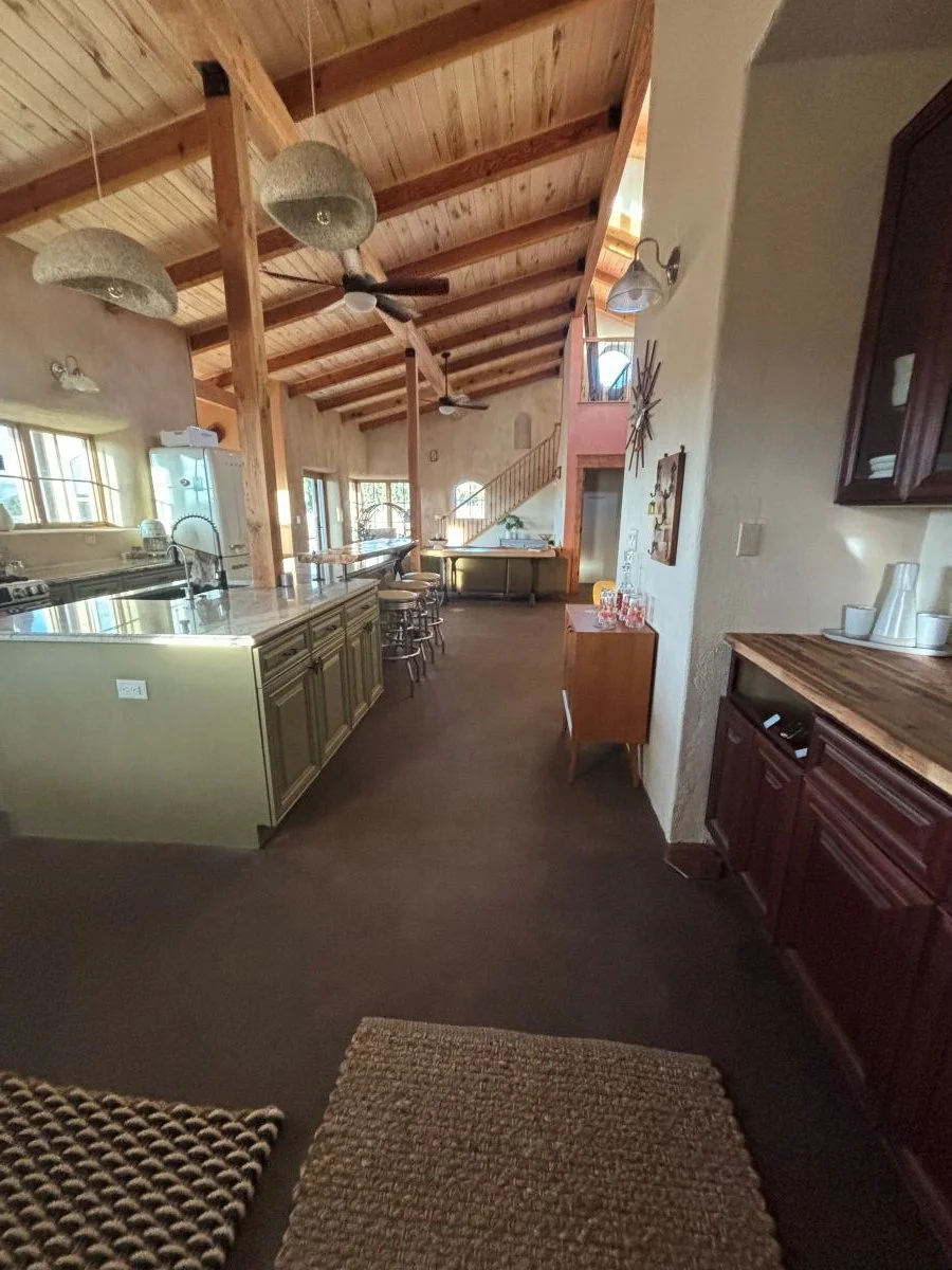 Etryway and kitchen passage withgreen kitchen cabinets.