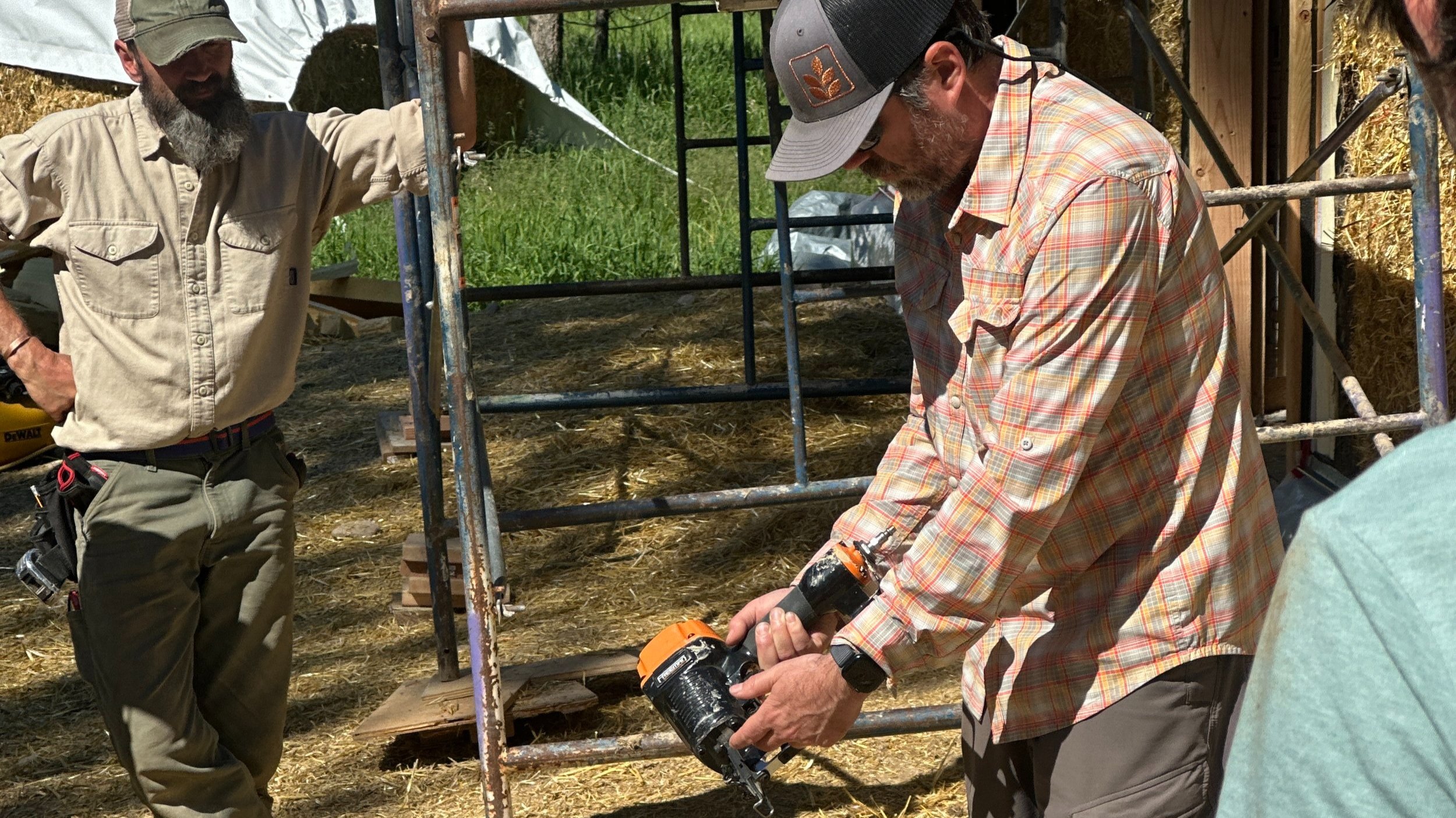 Man instructing the use of a pneumatic stapler.