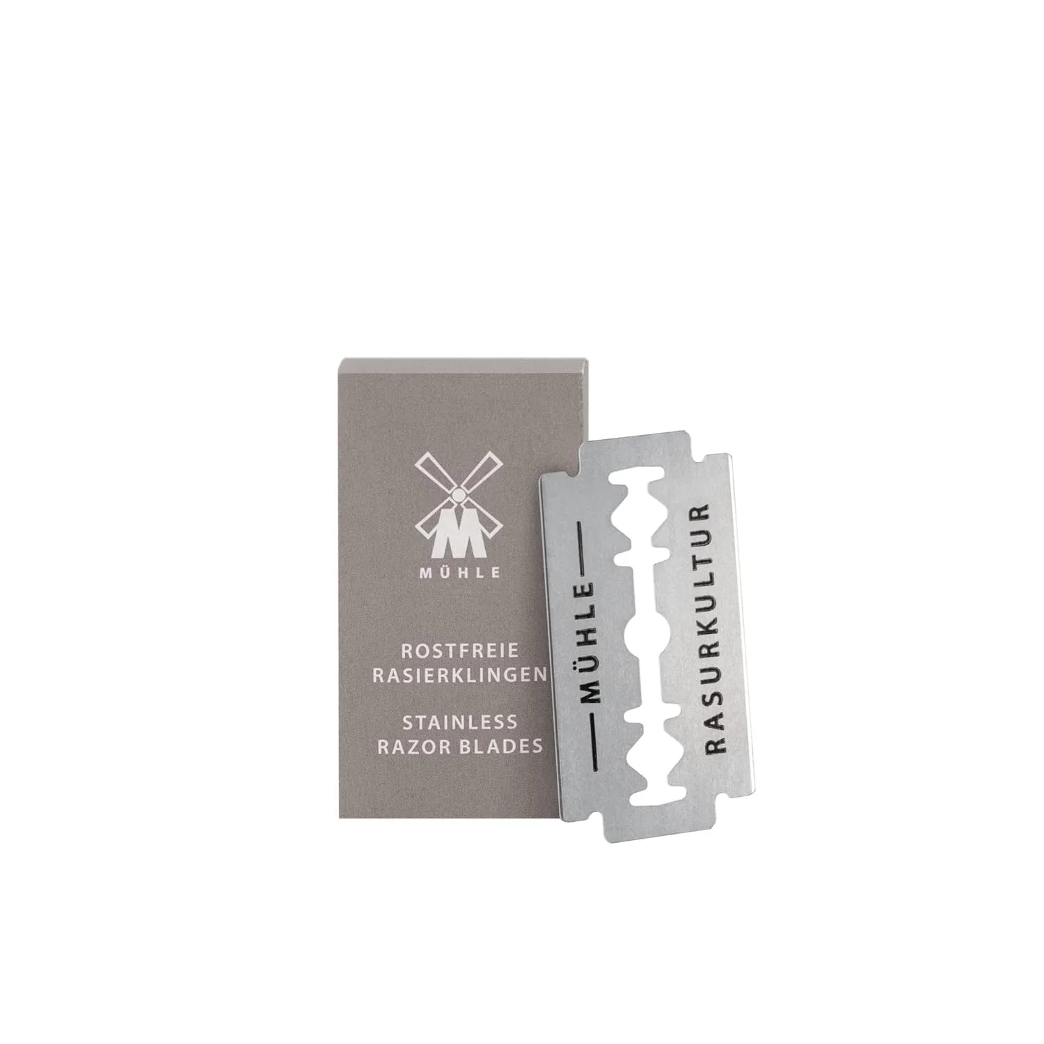 A pack of stainless razor blades with a box and one blade pulled out, displaying the words 'MÜHLE ROSTFREIE RASIERKLINGEN' and 'STAINLESS RAZOR BLADES' in German and English.