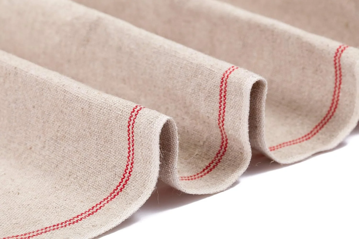 Close-up of folded beige linen fabric with red stitched border.