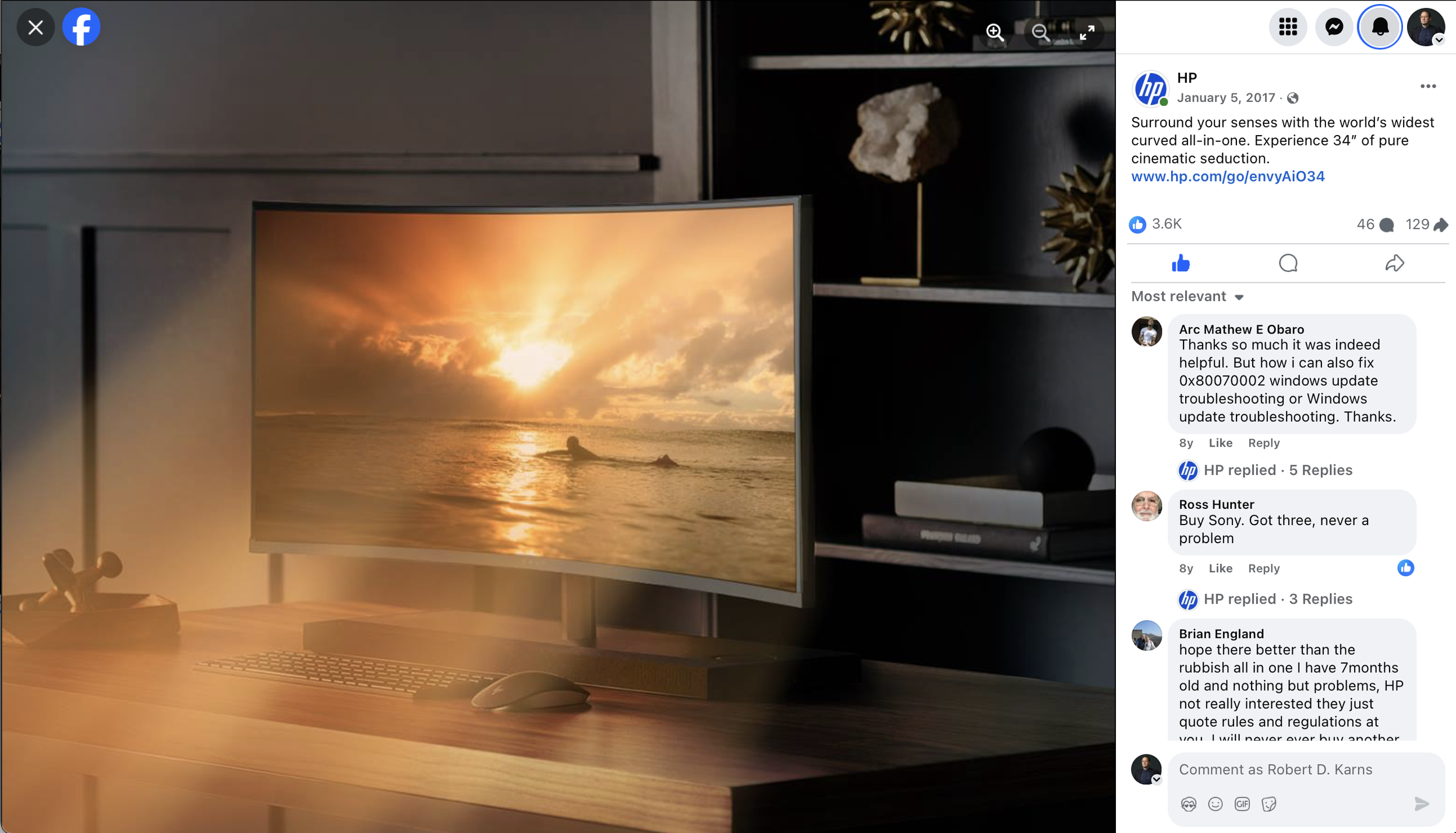 Curved monitor displaying a scenic sunset over the ocean on a wooden desk with a keyboard and mouse, next to shelves with decorative items, featured in an HP Facebook post dated January 5, 2017.