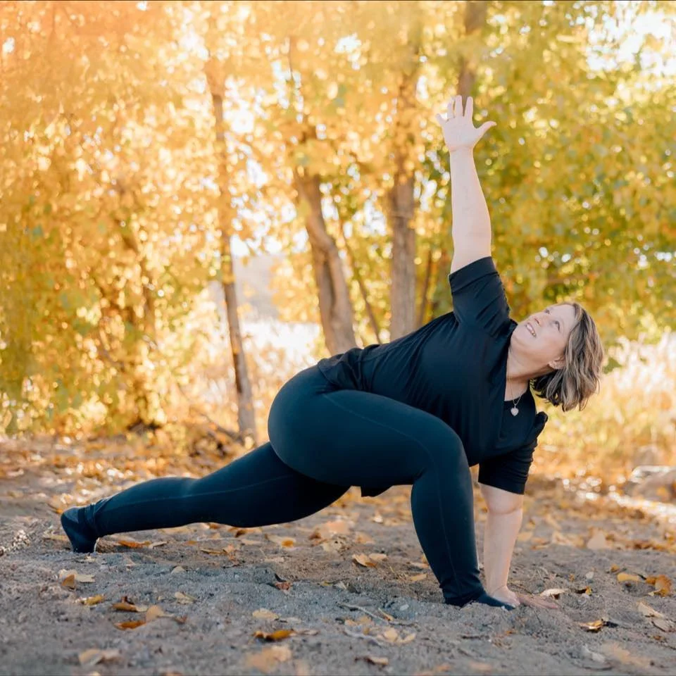 Three women practicing meditation or yoga indoors, sitting cross-legged with hands on their chests, eyes closed.