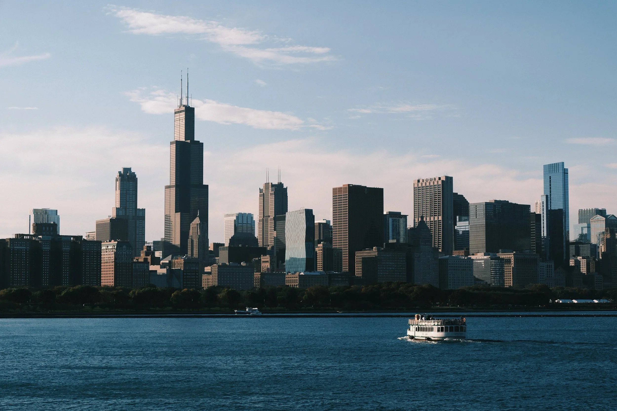 The Chicago skyline across the lake, with a boat passing
