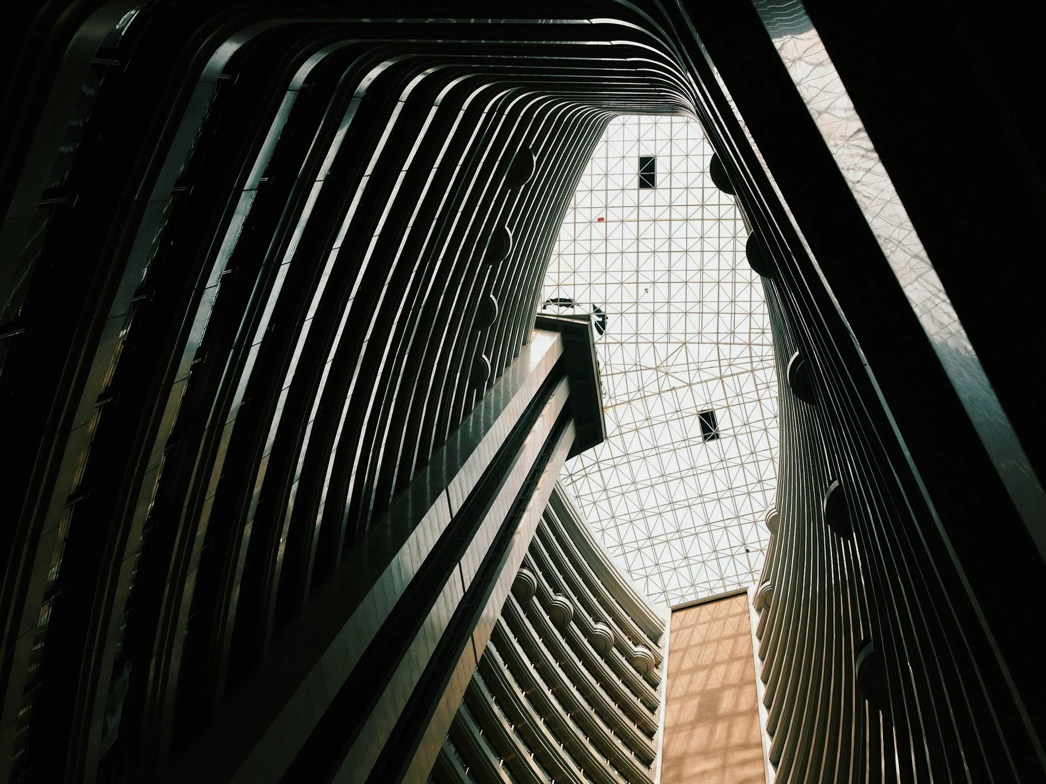 Looking up through a curving slatted atrium to the sky