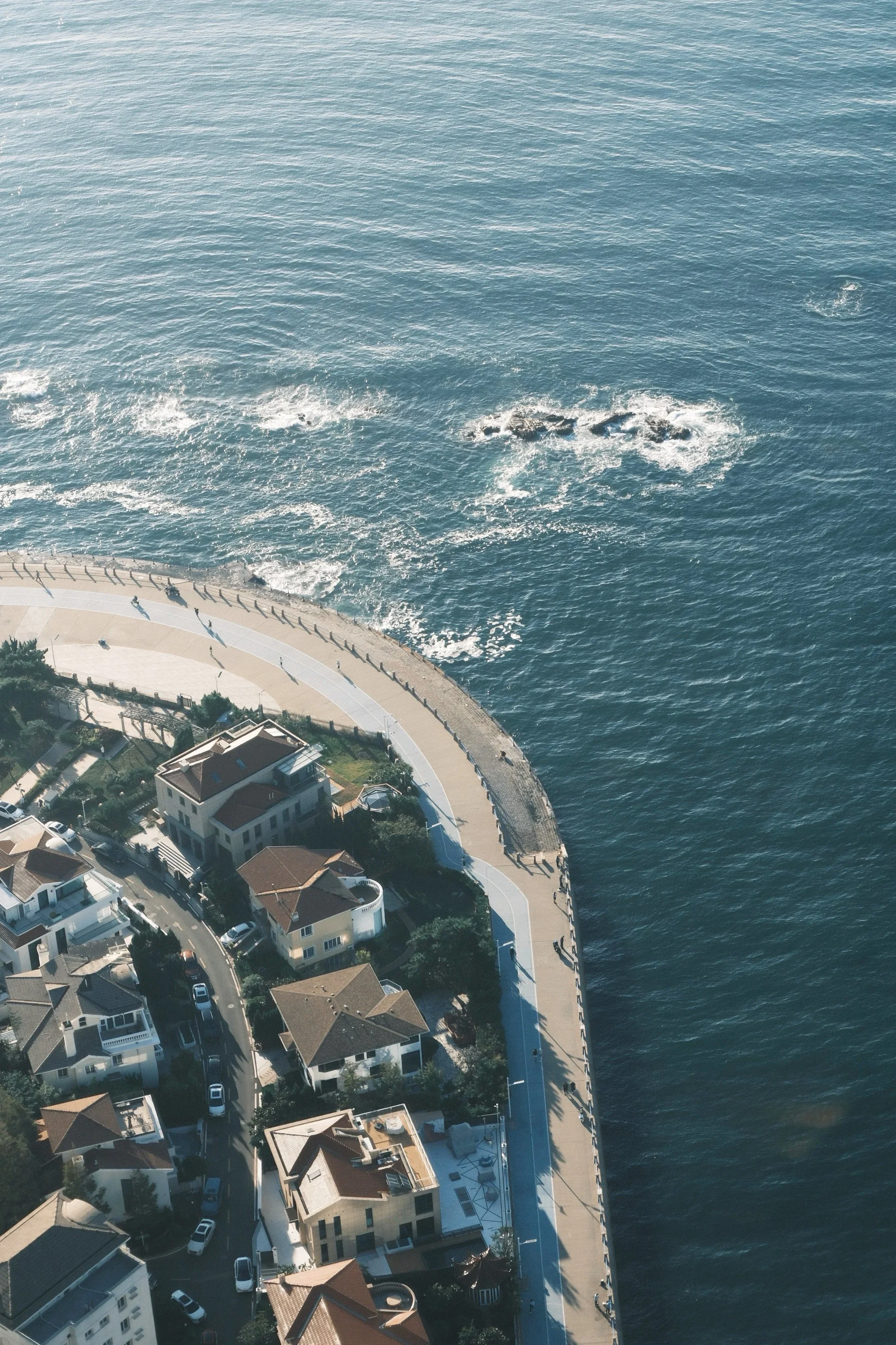 An aerial view of the coastline curling around a neighborhood
