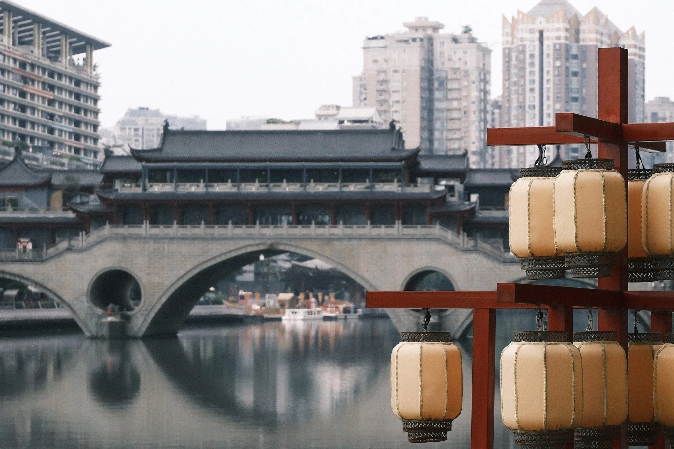Red lanterns in front of the covered bridge over the river in Chengdu