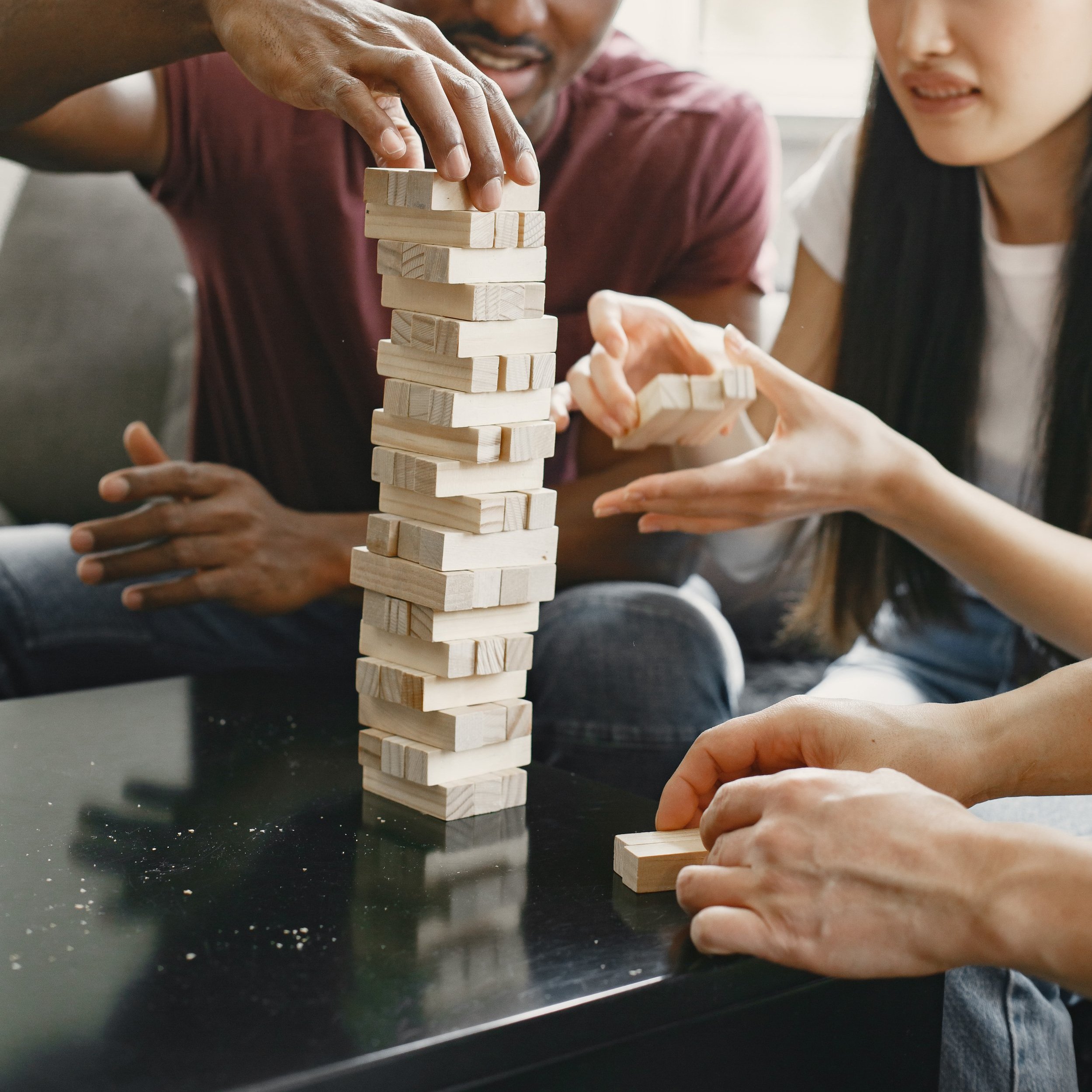 three-friends-playing-jenga-in-the-living-room-2024-12-06-20-24-27-utc.jpg