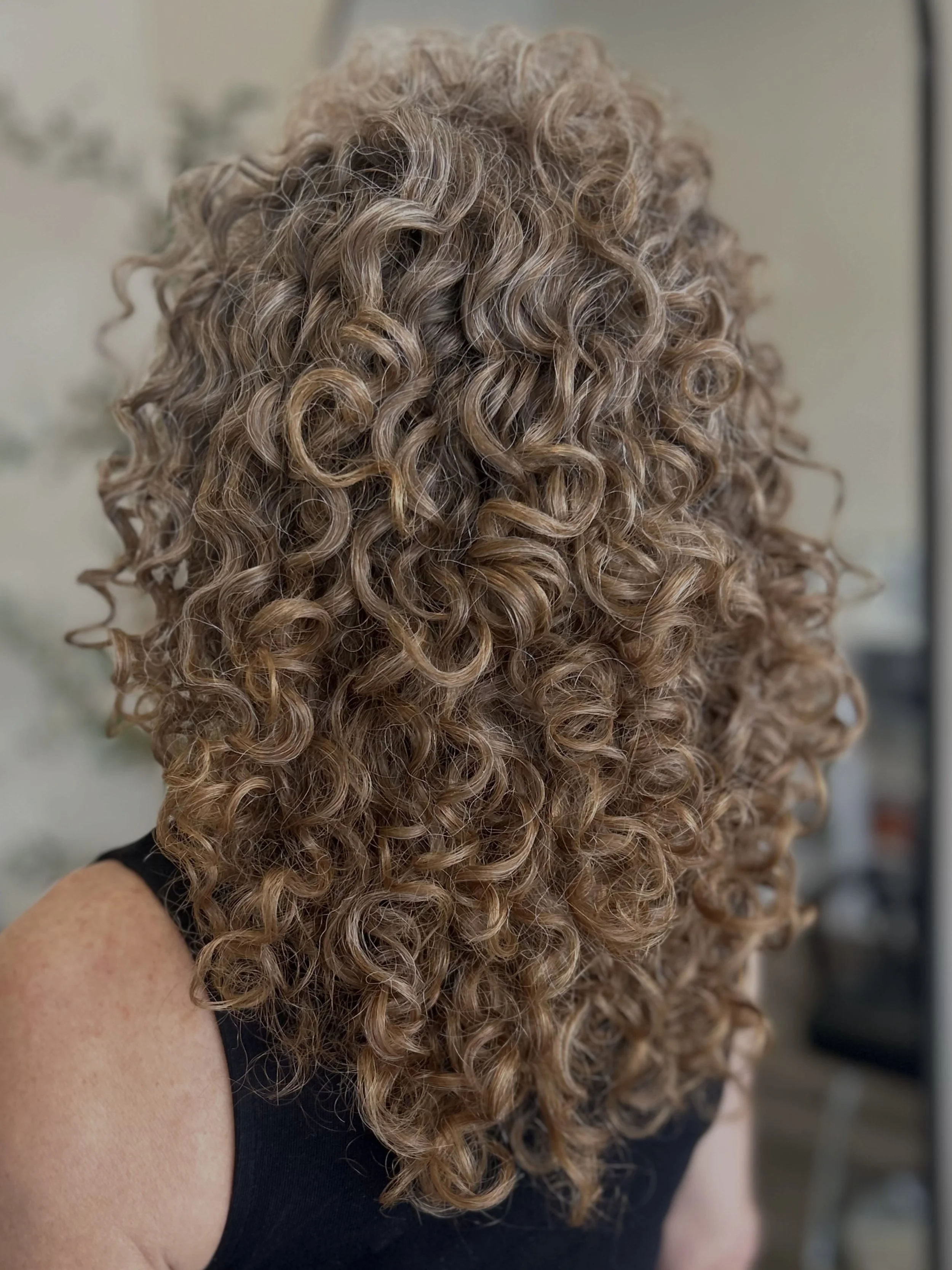 Long strawberry blonde curly hair cut with perfectly styled natural ringlets