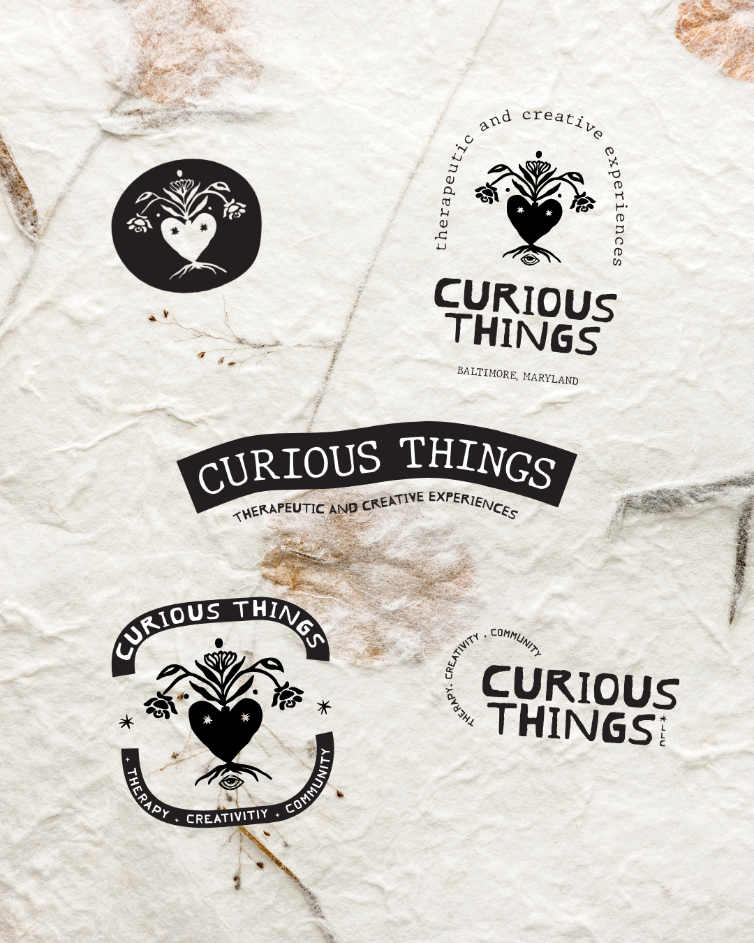Multiple black and white logos for Curious Things, a therapy and creative experiences business, with heart and floral designs, on textured paper.
