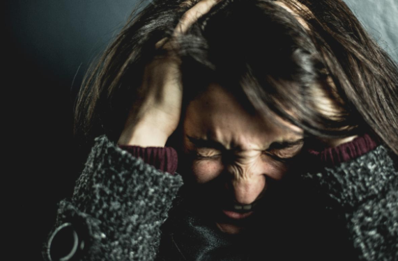 A woman running her hands through her hair in a very stressed and frustrated look