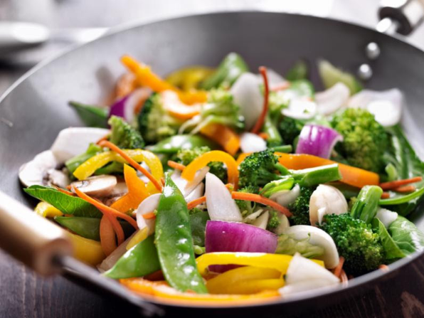 A colorful stirfry cooking in a wok