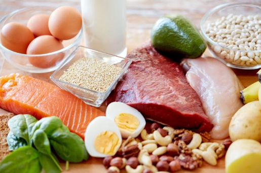 An assortment of protein sources, including eggs, salmon, beef, nuts, milk, and chicken