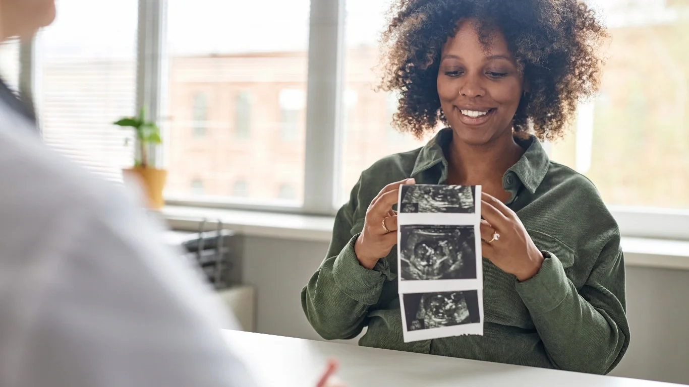 Black mother holding newborn, representing the need for Black maternal health providers in postpartum care