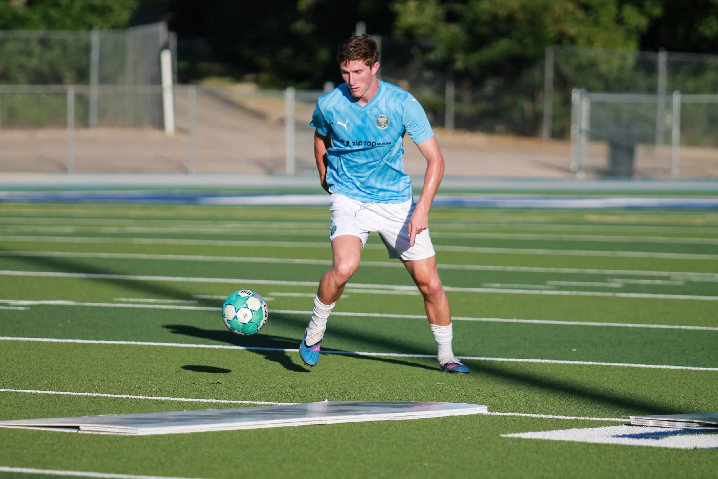 McKinney Chupacabras FC defender Luke Adams carries the ball during a 2026 USL League Two match at Ron Poe Stadium.