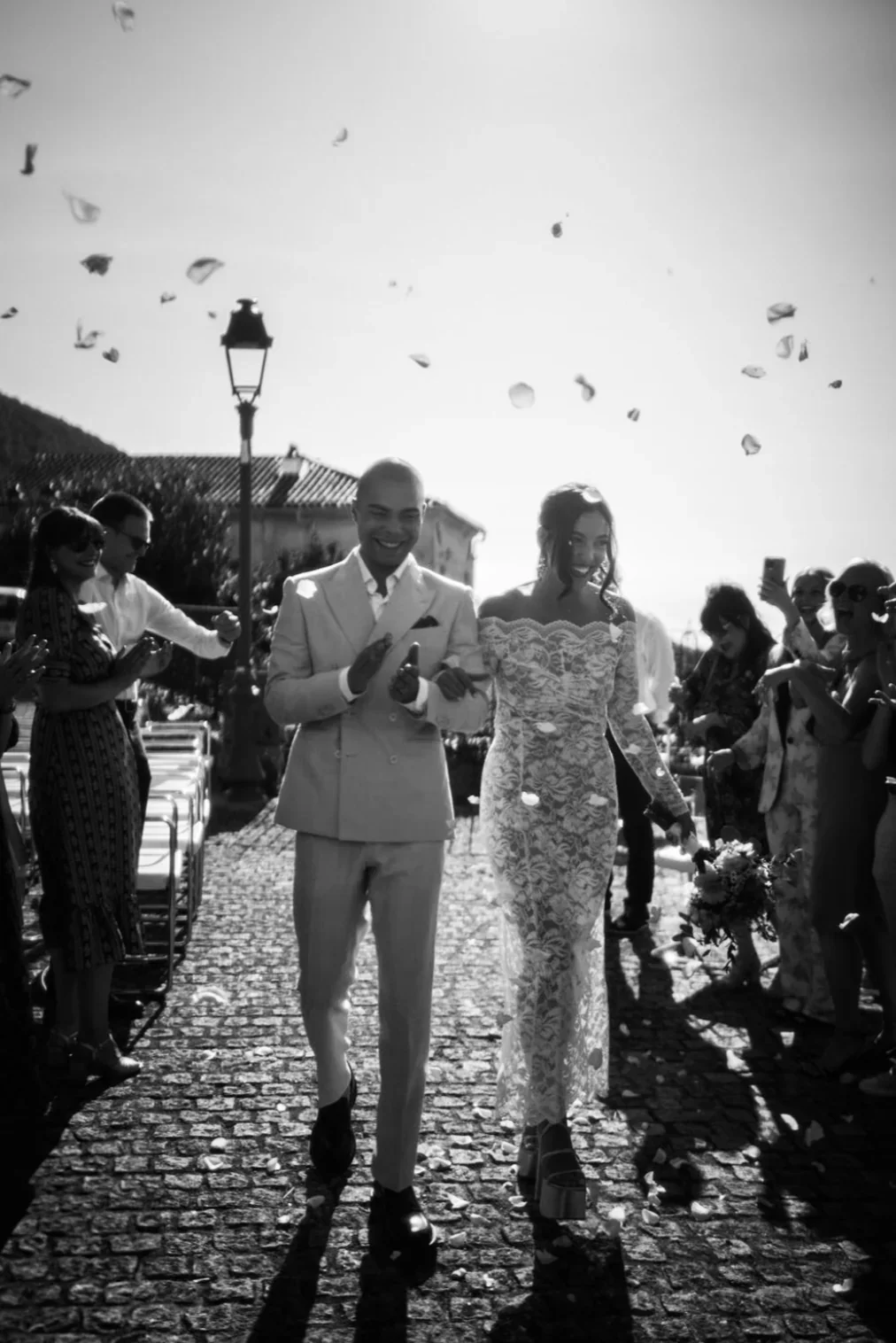 sortie-ceremonie-maries-confettis-petales-rues-cobblestones-provence-destination-wedding-photographe-mariage-film-mariage-the-wild-strawberry.webp