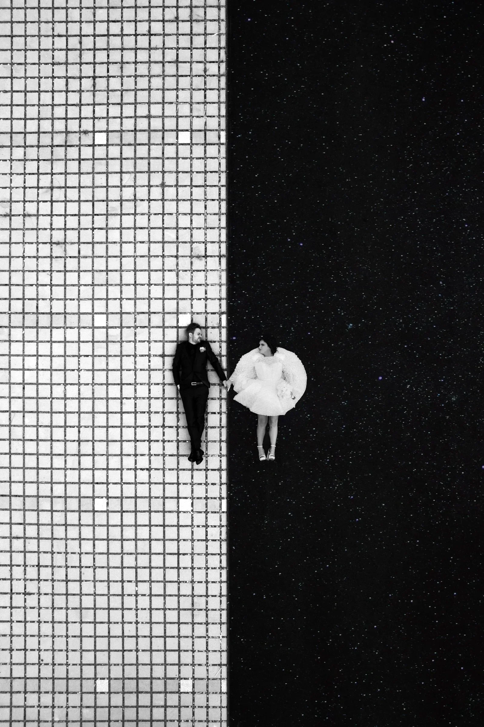 couple-maries-vue-aerienne-carreaux-sol-urban-paris-photographe-mariage-video-mariage-the-wild-strawberry.webp