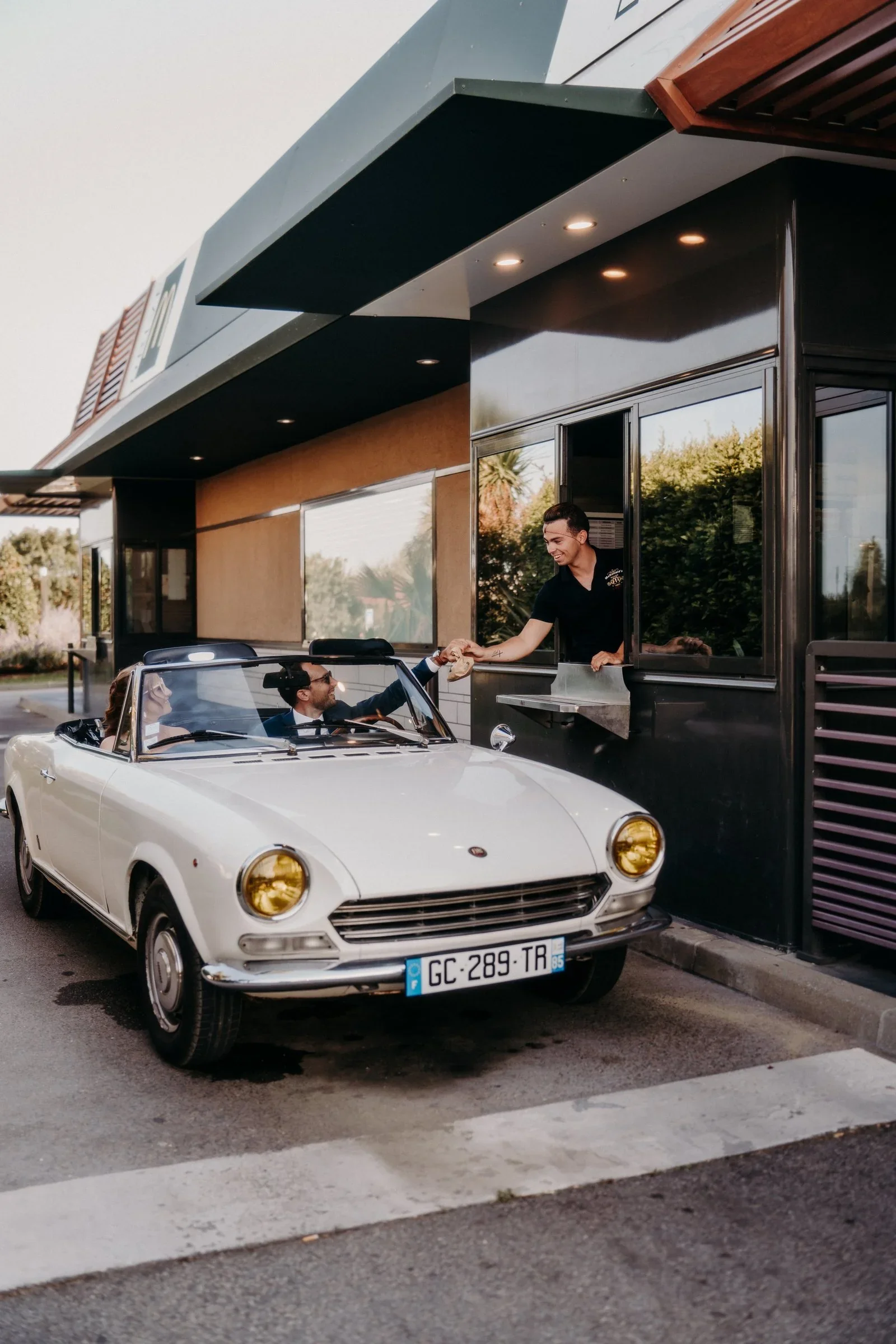couple-maries-voiture-cabriolet-vintage-drive-in-mariage-insolite-photographe-mariage-video-mariage-the-wild-strawberry.webp