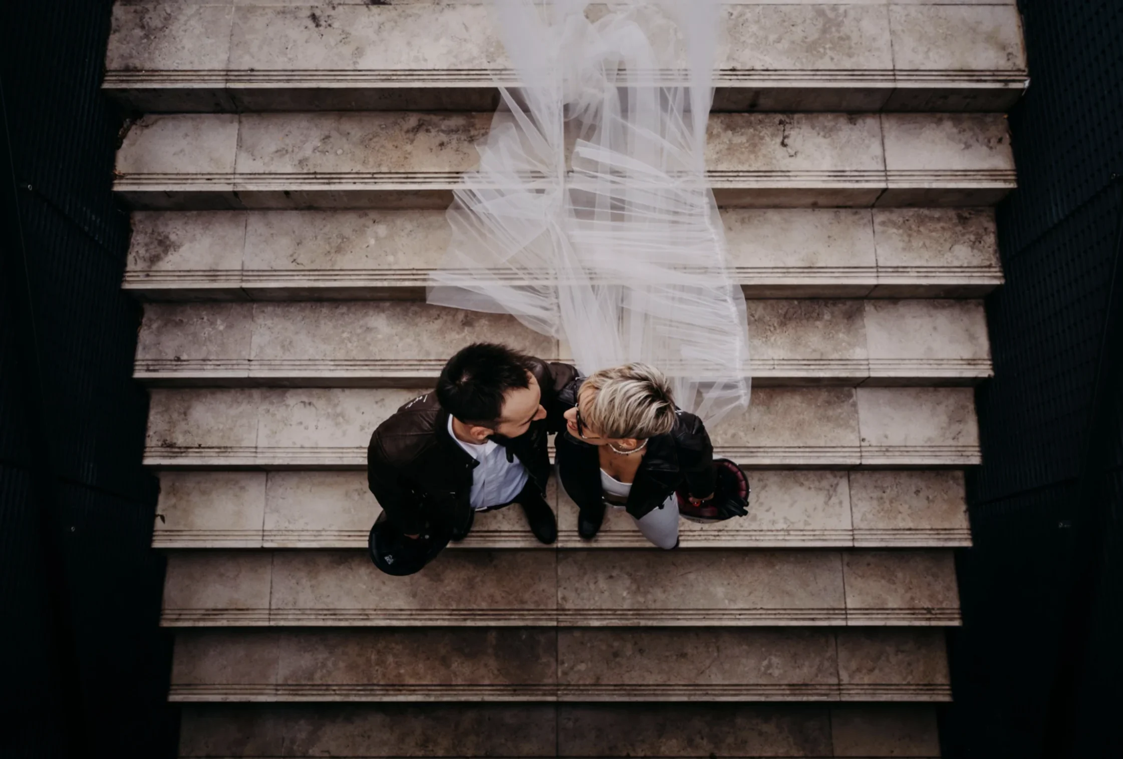 vue-aerienne-portrait-couple-maries-escalier-voile-editorial-photographe-mariage-film-mariage-the-wild-strawberry.webp
