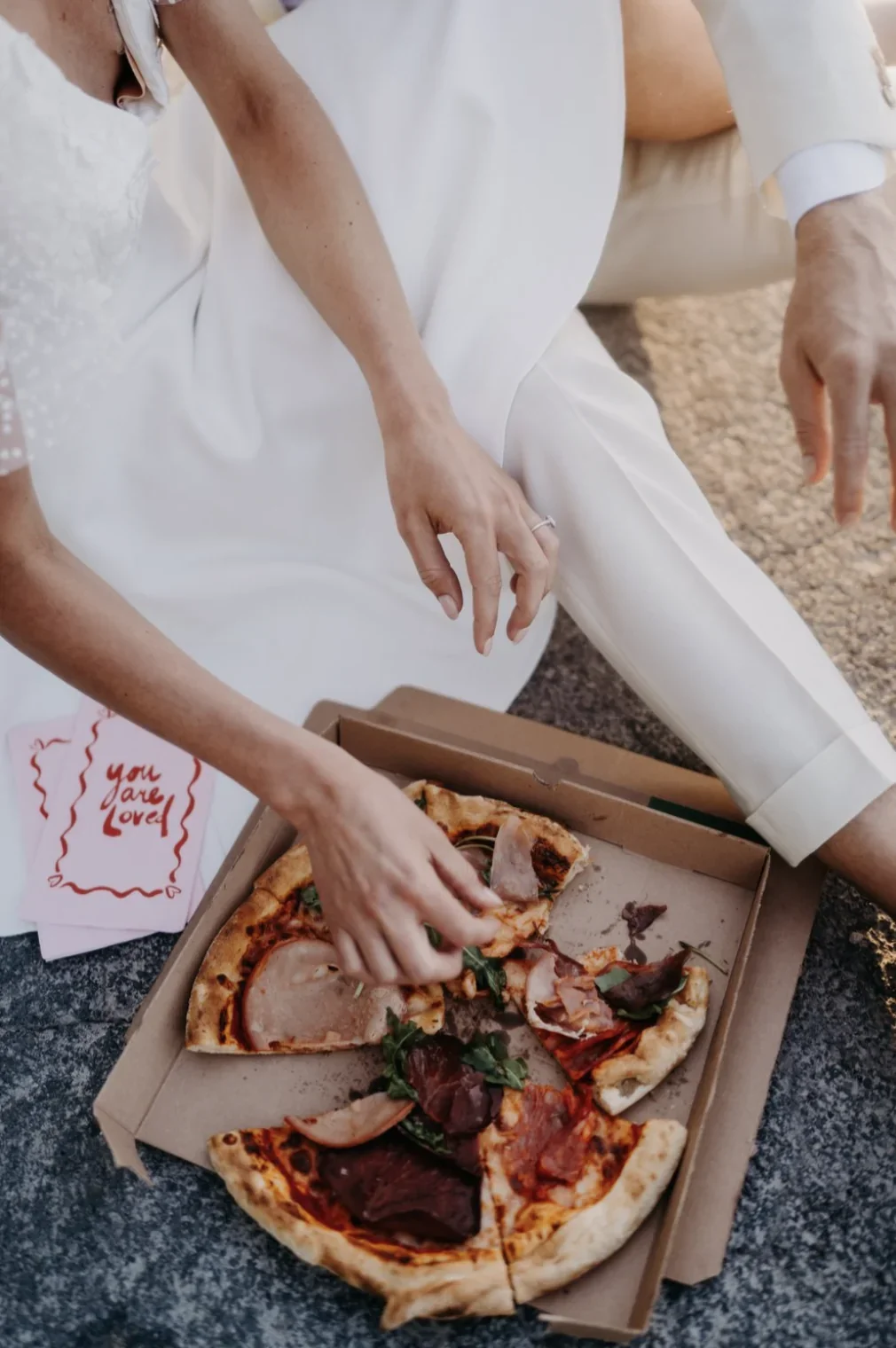 portrait-couple-maries-pizza-fun-insolite-you-are-loved-photographe-mariage-film-mariage-the-wild-strawberry.webp