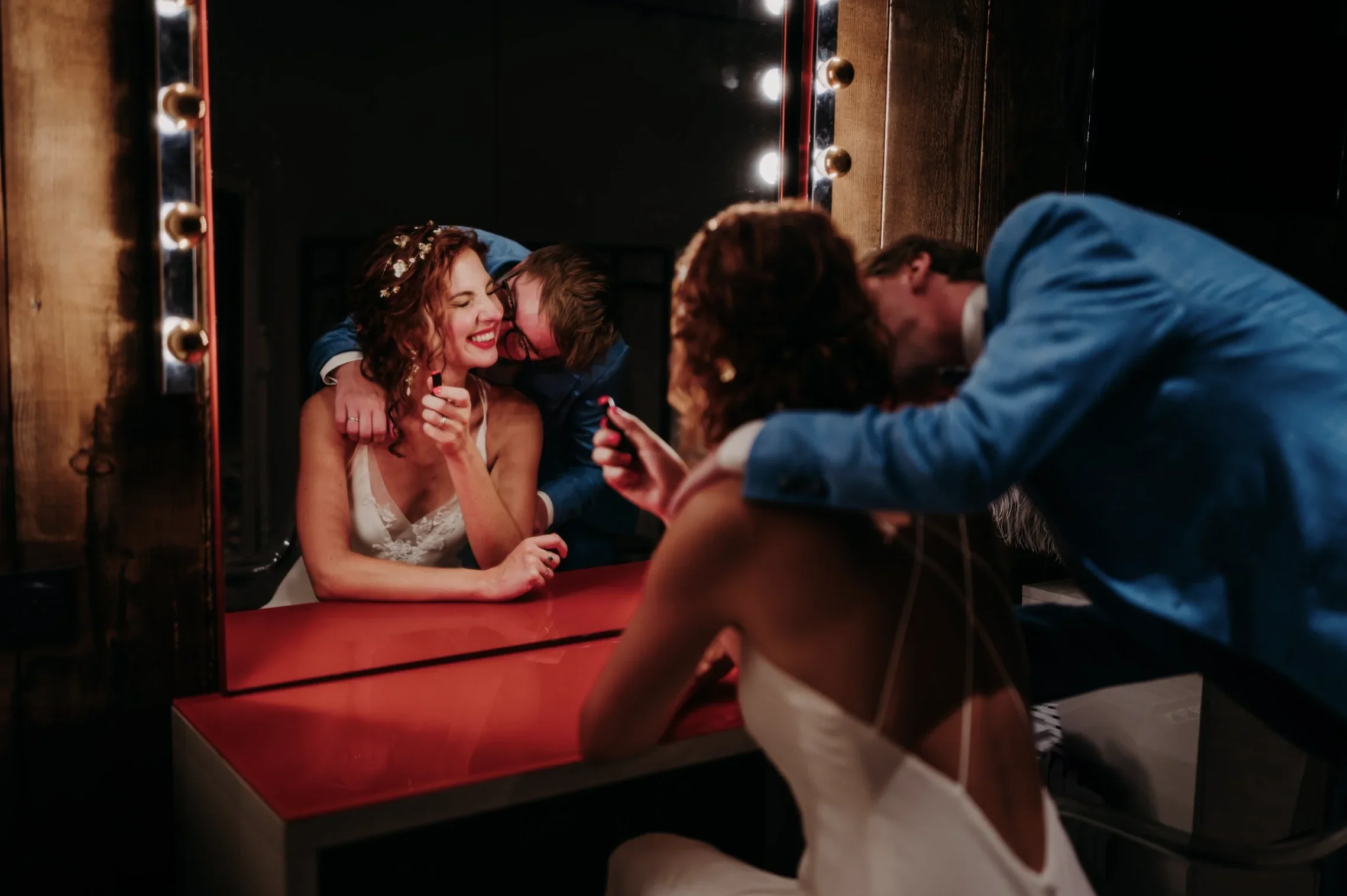 portrait-couple-miroir-loges-dressing-fun-soiree-mariage-photographe-mariage-video-mariage-the-wild-strawberry.webp