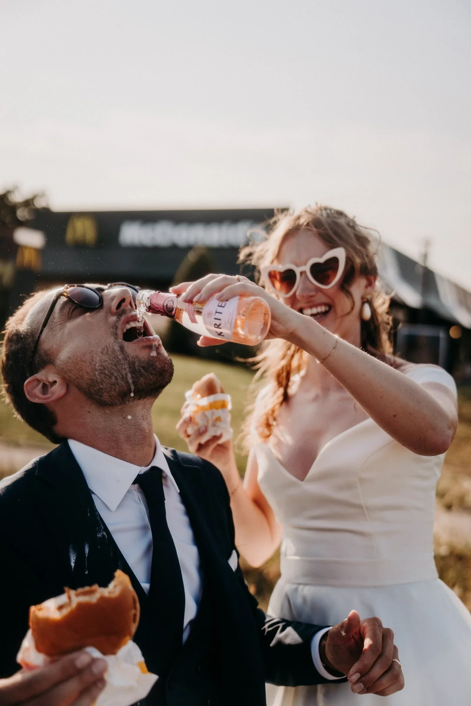 couple-maries-mcdonalds-frites-champagne-mariage-insolite-photographe-mariage-video-mariage-the-wild-strawberry.webp