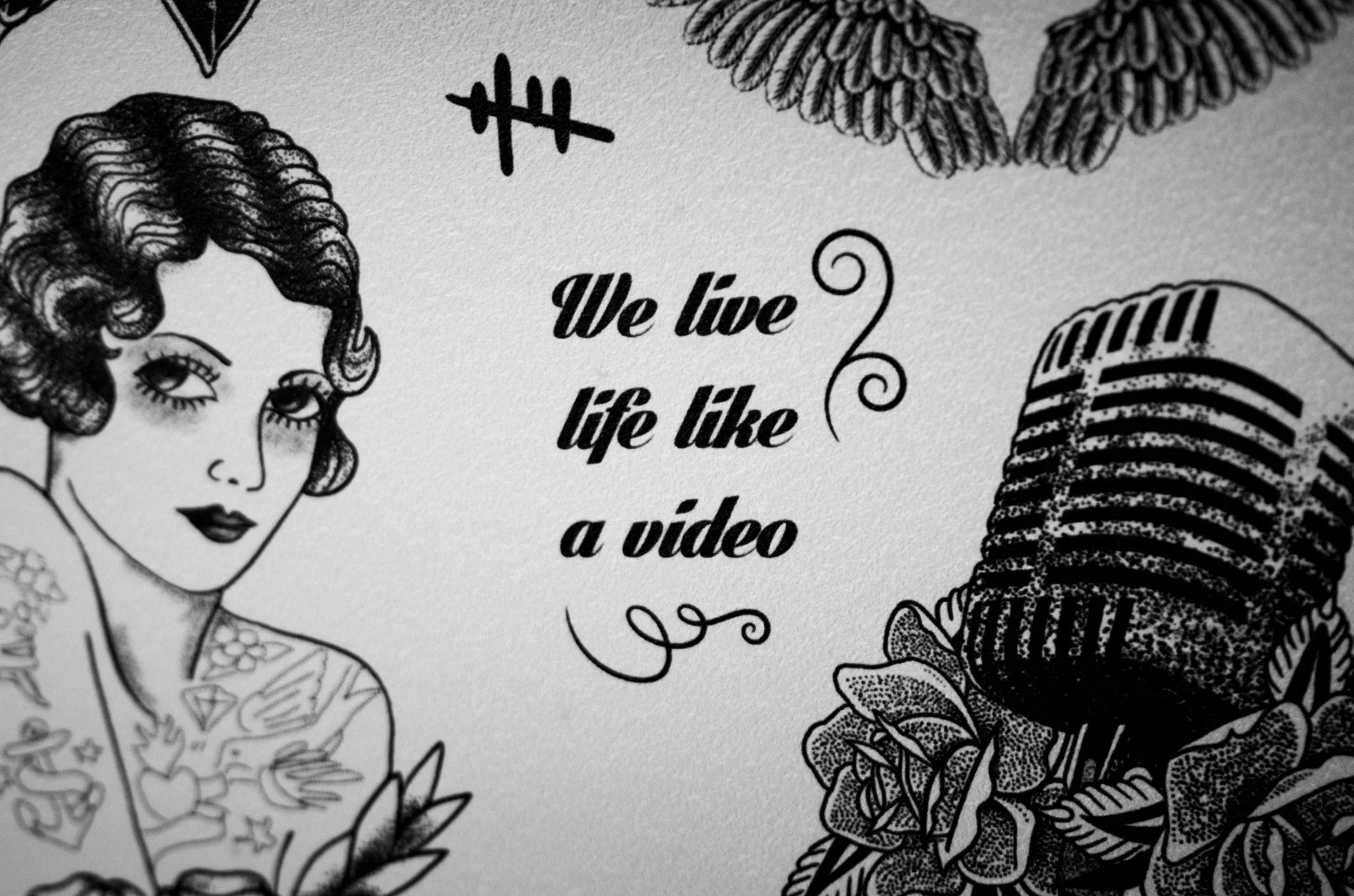 decor-mariage-mural-citation-rock-vintage-we-live-life-like-a-video-photographe-mariage-video-mariage-the-wild-strawberry.webp