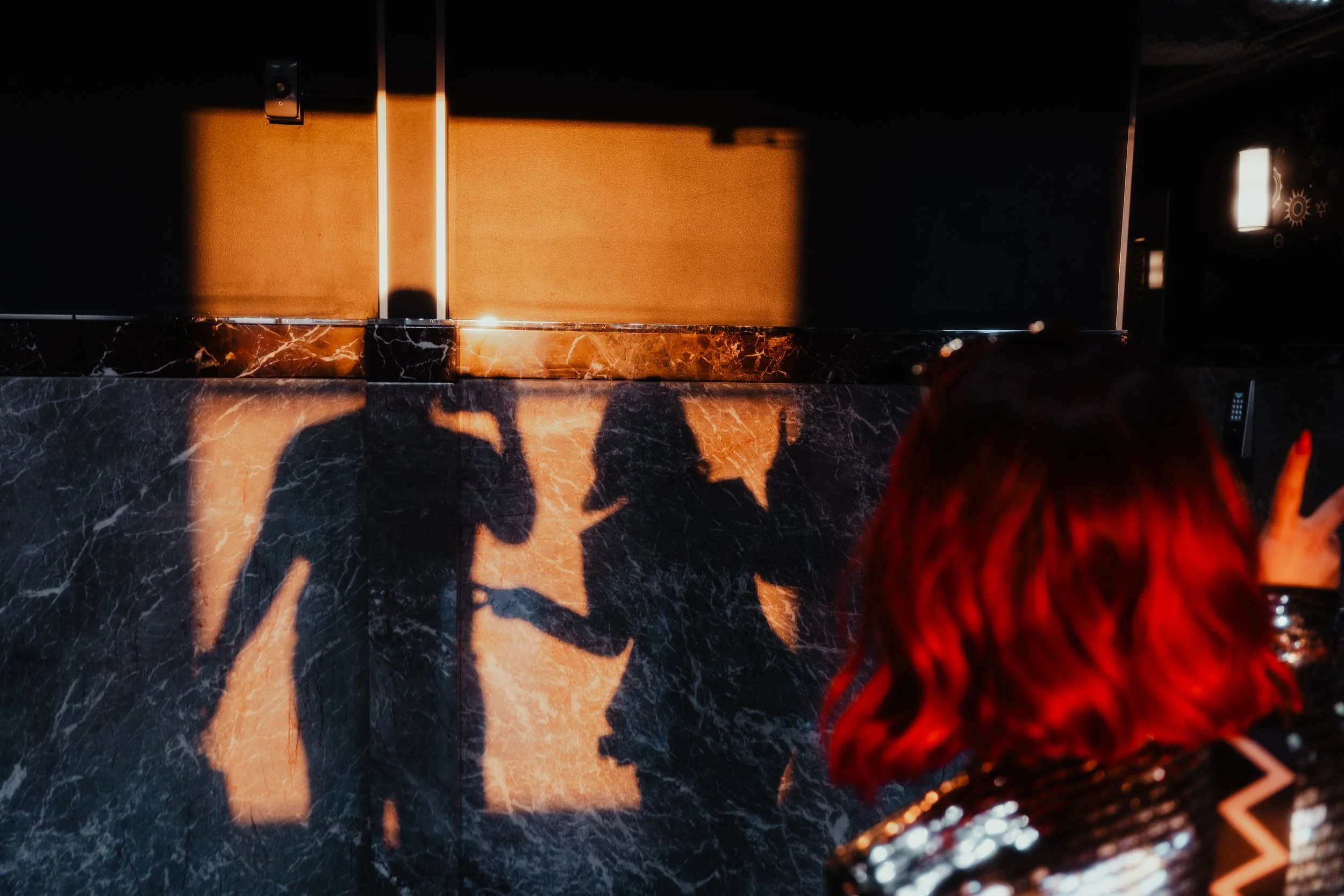 Ombres projetées sur un mur en marbre noir par la lumière derrière une porte en bois