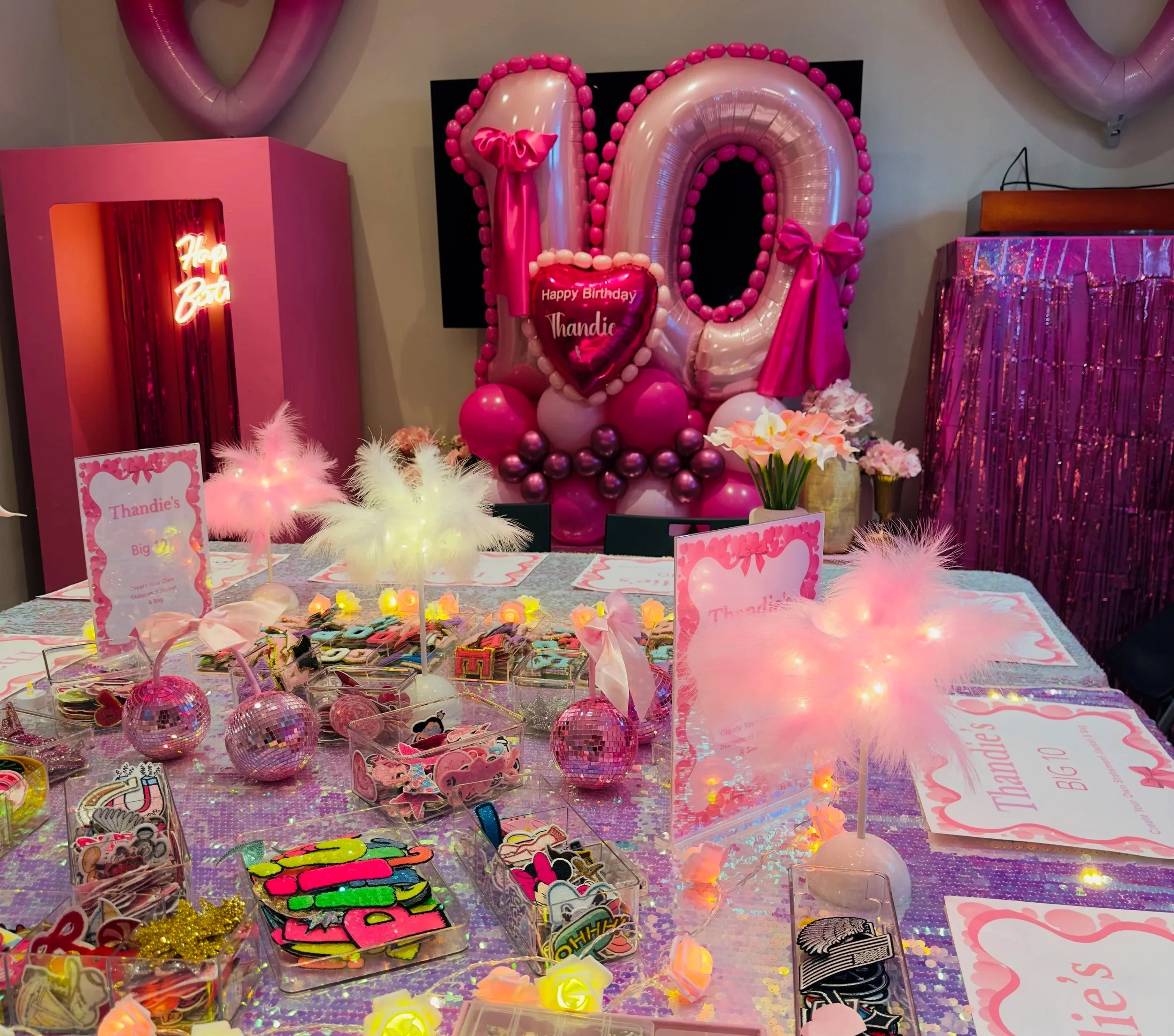 Luvlybubbly denim patch party table with personalised placemats, colourful patches, pink disco balls, flowers and feather decorations.