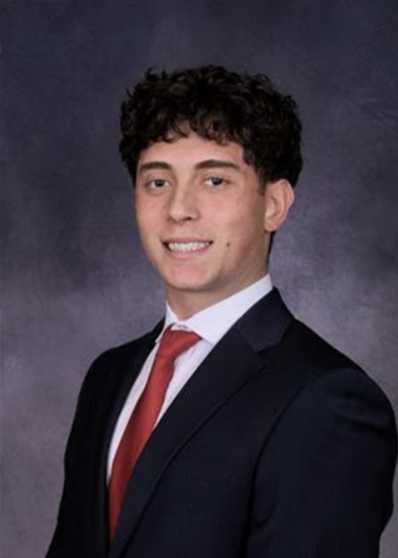 A portrait of a young man in a suit with dark short curly hair