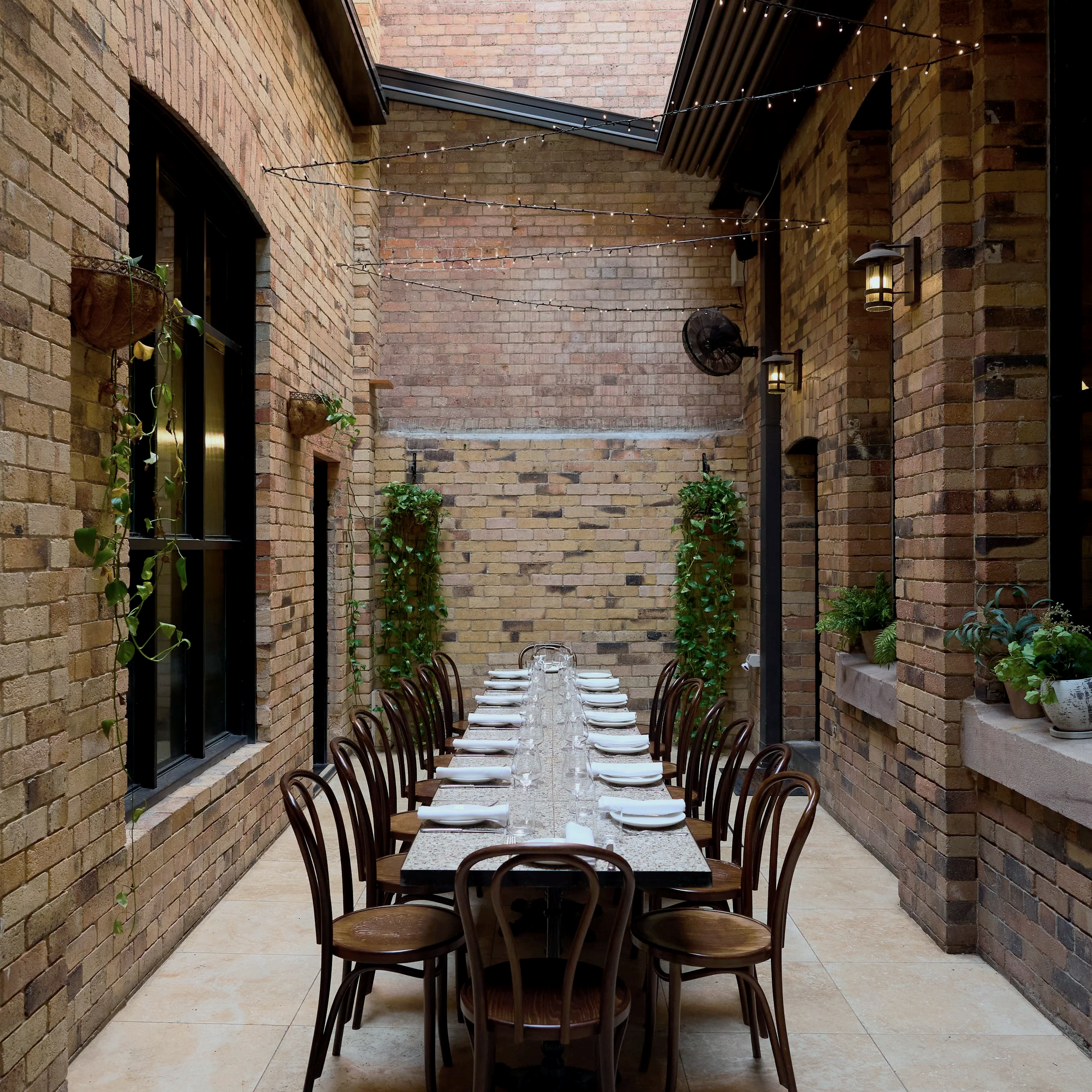 Courtyard dining at Rosmarino restaurant, Fortitude Valley Brisbane — long table set for 35 guests